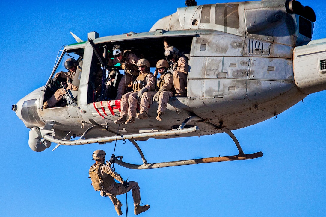 A U.S. Marine rappels from a UH-1N Huey helicopter during a rope exercise as part of Eager Lion 2013 on King Faisal Air Base, Jordan, June 11, 2013. The multinational exercise is designed to strengthen military-to-military relationships, and enhance security and stability in the region by responding to modern-day security scenarios. The helicopter is assigned to Marine Medium Tiltrotor Squadron 266.  
