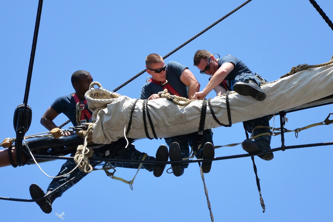 U.S. sailors secure a sail to a yard on the mizzenmast of the USS Constitution in Charleston, Mass., June 17, 2013. The Constitution's sailors conduct training during spring and summer months to learn seamanship techniques used aboard "Old Ironsides" since the 1790s.  
