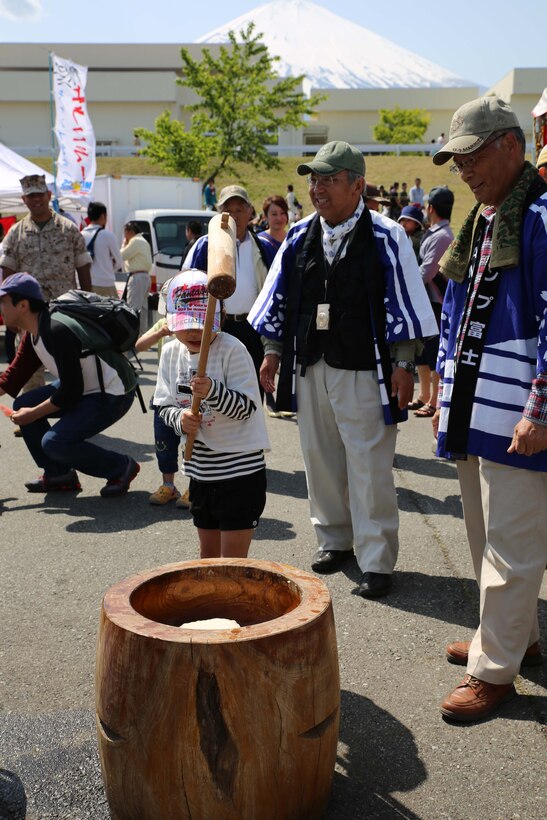 Community members pound rice to create mochi, a glutinous rice cake, May 10 during the Fuji Friendship Festival 2014 at Combined Arms Training Center Camp Fuji, Marine Corps Installations Pacific. The U.S.-Japan Fuji Friendship Association hosted the activity. Established nearly 14 years ago, the association coordinates events off base for Marines and sailors assigned to CATC Camp Fuji, like planting rice and the ceremonial hauling of large fish nets at Numazu, Japan, according to Wasaku Tatsumichi, the chief secretary of the association. 