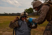 Petty Officer Third Class Josue Rivera Robles (right), an expanded function dental assistant with 2nd Dental Battalion, 2nd Marine Logistics Group takes a dental x-ray on the gun line of Golf Battery, 2nd Battalion, 10th Marine Regiment during Rolling Thunder, a biannual training exercise at Fort Bragg, N.C., May 9, 2014. The dental attachment to 2nd Maintenance Battalion, Combat Logistics Regiment 25, 2nd MLG conducted exams of service members with 10th Marines throughout Rolling Thunder.