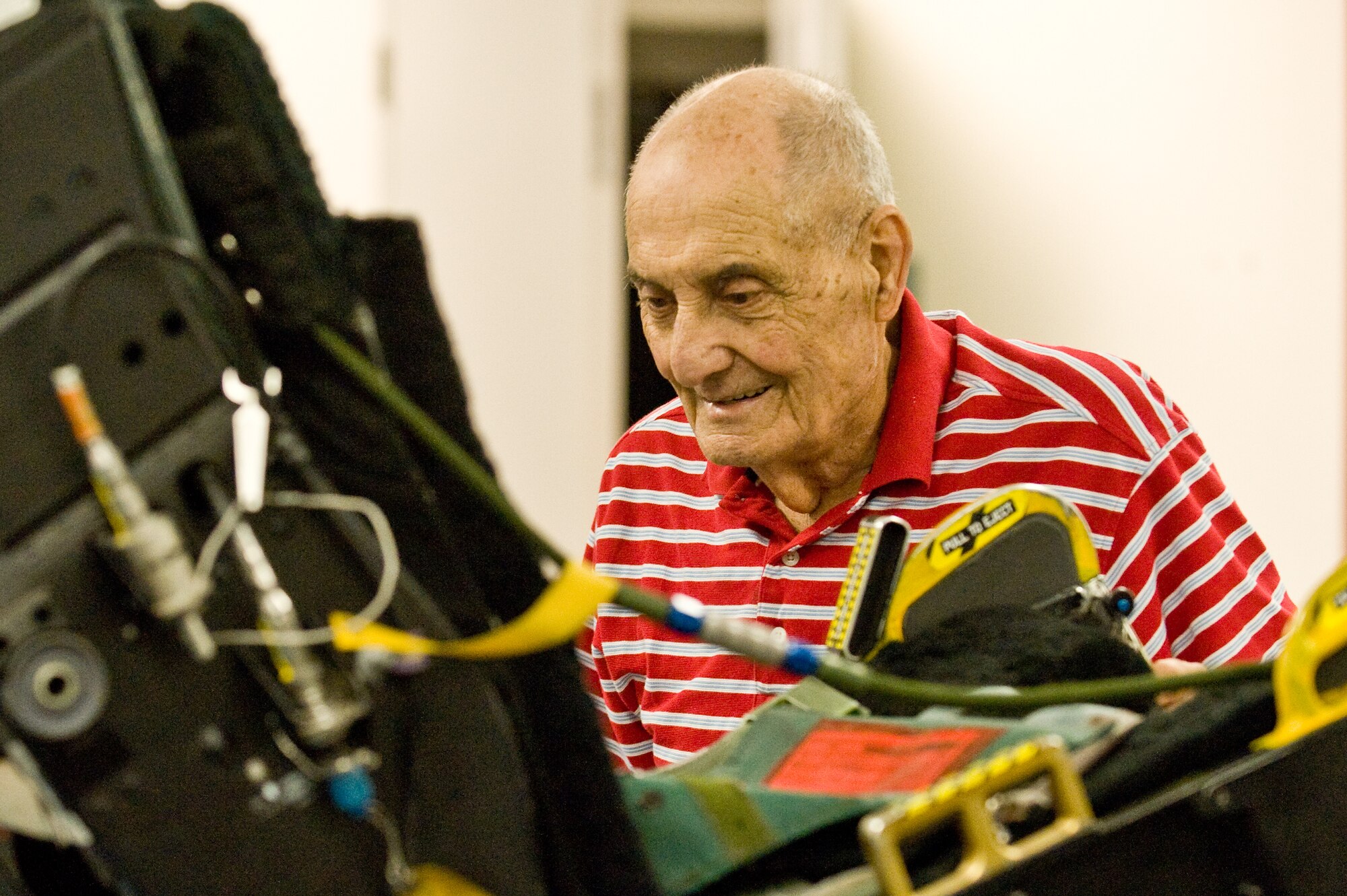 Retired Chief Master Sgt. George H. Fuller Sr. inspects a modern F-15E Strike Eagle aircraft’s ejection seat during a tour of the 4th Component Maintenance Squadron egress shop, April 30, 2014, at Seymour Johnson Air Force Base, N.C. Fuller said he was impressed to see the technological advances in egress since his time in the early 1950s. Fuller is considered to be the founder of the Air Force’s first egress shops. (U.S. Air Force photo/Airman 1st Class Aaron J. Jenne)
 