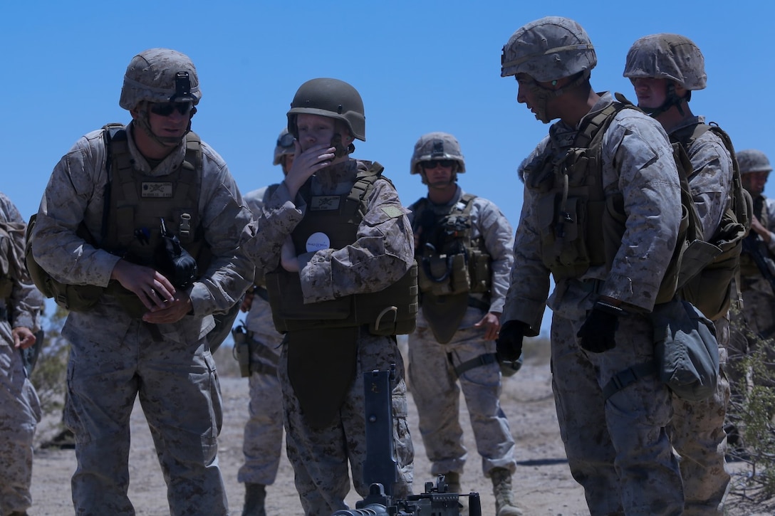 Ryan Forbes, second from left, a 13 year-old native of San Diego, talks with Marines about various weapon systems at Marine Corps Air Ground Combat Center Twentynine Palms May 13, 2014. Forbes was an honorary Marine for a day with Lima Battery, 3rd Battalion, 11th Marine Regiment, and learned about the lifestyles of the Marines. He was accompanied by his parents and brother, and attended training with the battery, learning about how to set up and take down an M777 lightweight howitzer and eating lunch with a section. Forbes has wanted to join the military for several years and spends time learning what it would take to get through boot camp. He was diagnosed with medulloblastoma, a form of brain cancer in January. His diagnosis and current treatment for medullablastoma hasnt hampered his enthusiasm for the military.