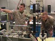 Two Marines calibrate a torque wrench using the torque standard from the Expeditionary Test, Diagnostic and Measurement Equipment Maintenance System. The ETMS lets Marines calibrate test equipment in 28 different test areas. 