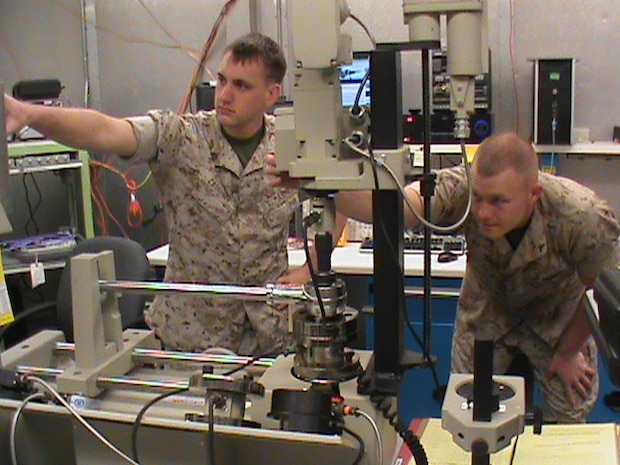 Two Marines calibrate a torque wrench using the torque standard from the Expeditionary Test, Diagnostic and Measurement Equipment Maintenance System. The ETMS lets Marines calibrate test equipment in 28 different test areas. 