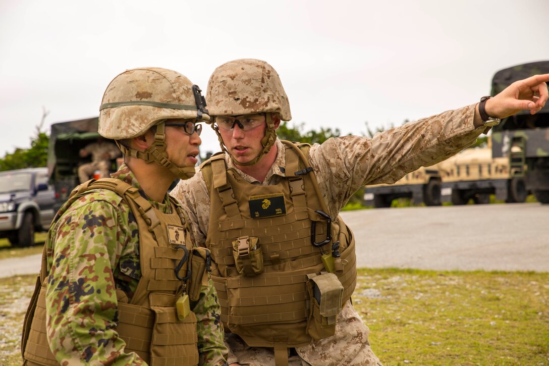 Japan Ground Self-Defense Force 2nd Lt. Kyohei Aikawa, left, observes machine gun targets pointed out by U.S. Marine Sgt. David C. Nicol May 8 in the Central Training Area during a quarterly Marine Corps common skills training evolution specifically designed for bulk fuel specialists. Aikawa is currently taking part in the Japan Observer Exchange Program, which allows JGSDF service members to spend time with U.S. Marines. Aikawa was observing Bulk Fuel Company, 9th Engineer Support Battalion, as they trained with medium machine guns to provide their own security in a combat environment. Aikawa is a combat engineer officer with 2nd Division, 2nd Engineer Battalion, headquartered in Hokkaido, Japan. Nicol is a squad leader and bulk fuel specialist with Bulk Fuel Headquarters Company, 9th ESB, 3rd Marine Logistics Group, III Marine Expeditionary Force.
