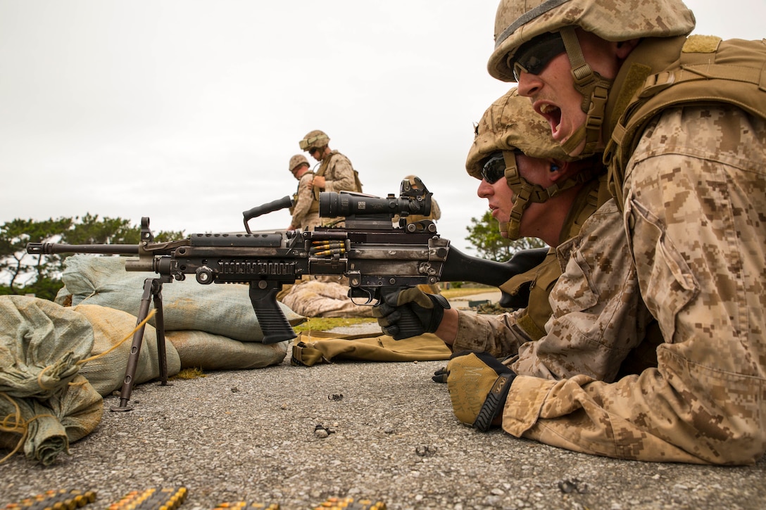 Cpl. Raymond P. Sanborn, right, shouts, “gun two ready!” as Lance Cpl. Wesley L. Dorman keeps his finger straight and off the trigger, waiting for the command to fire an M249 squad automatic weapon May 8, 2014 in the Central Training Area. The Marines executed a quarterly Marine Corps common skills training evolution specifically designed for bulk fuel specialists. The Marines trained with M249 SAWs and M240B medium machine guns to provide security in a forward deployed environment. Sanborn and Dorman are bulk fuel specialists with Bulk Fuel Headquarters Company, 9th Engineer Support Battalion, 3rd Marine Logistics Group, III Marine Expeditionary Force.