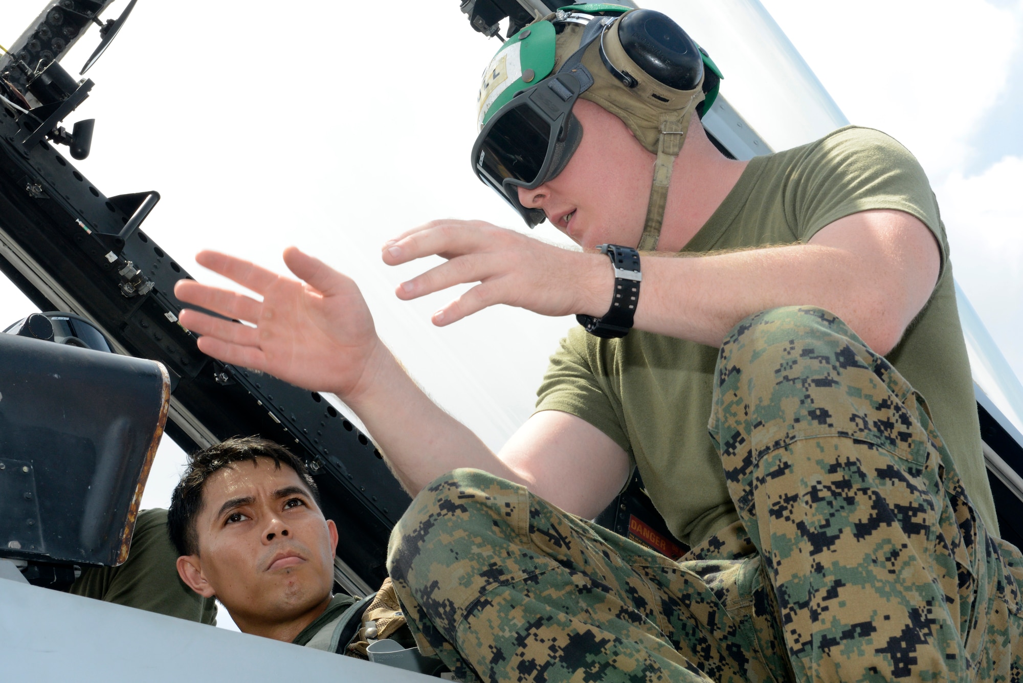 Philippine Air Force Capt. Jose W. Martinez, left, and U.S. Marine Sgt. Brian Wise go through a pre-check list before a familiarization flight in an F/A-18 Hornet aircraft at Clark Air Field, Philippines, May 9 during Balikatan 2014. This annual training exercise strengthens the interoperability between the Armed Forces of the Philippines and U.S. military in their commitment to regional security and stability, humanitarian assistance and disaster relief. Wise is a seat mechanic with Fixed Wing Marine All Weather Fighter Attack Squadron 224. Martinez is a pilot with Philippine Air Force Air Defense Wing. (U.S. Air Force photo by Tech. Sgt. Raymond Mills/Released)
