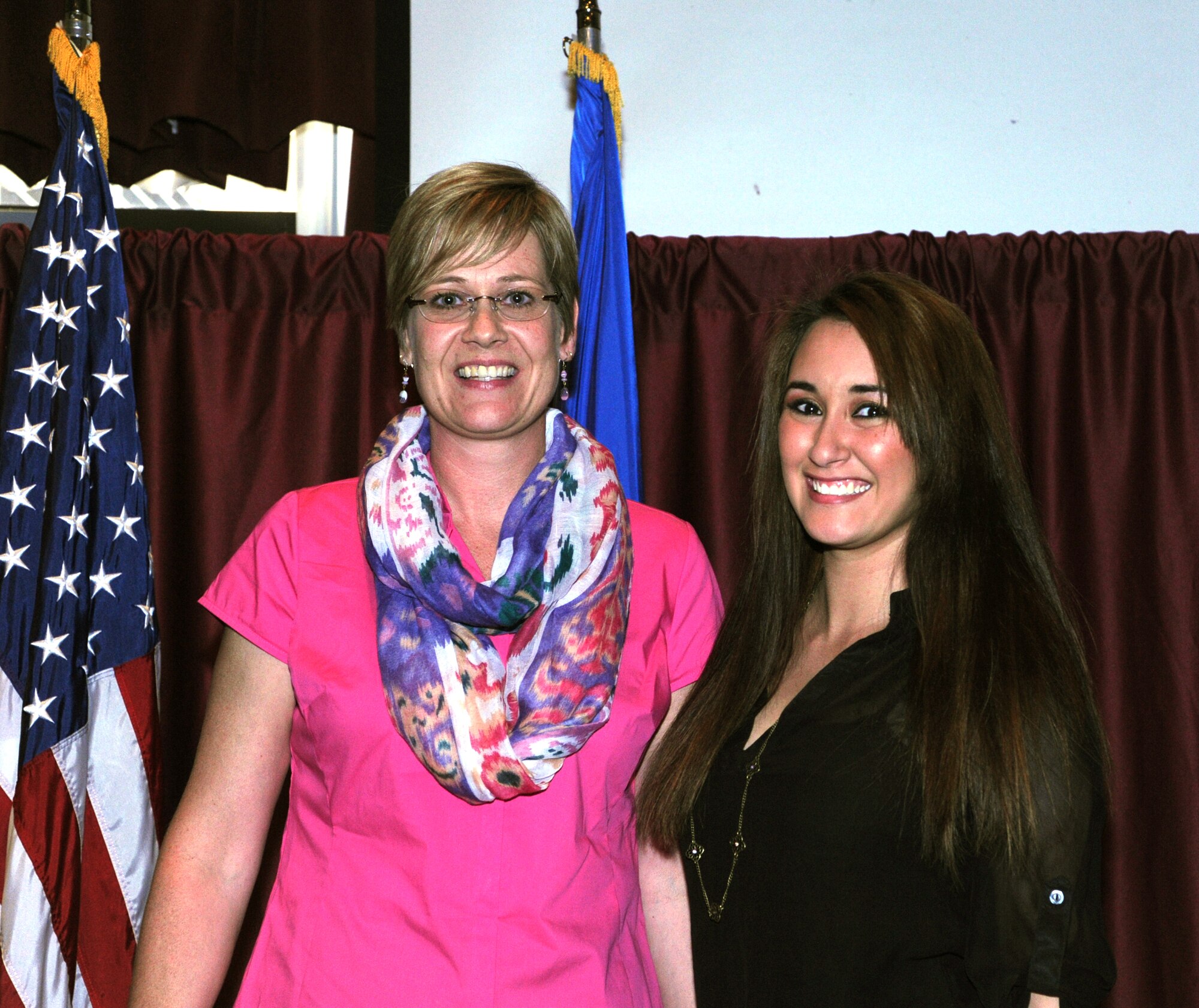 Ankie Richard, OSC president, left, congratulates Elena Gartland, recipient of a $2,000 scholarship, during the OSC scholarship presentation at the Vance Club May 13 . Gartland will use the scholarship to pursue a master’s in curriculum and instruction from the American College of Education. (U.S. Air Force photo/Senior Airman Frank Casciotta)