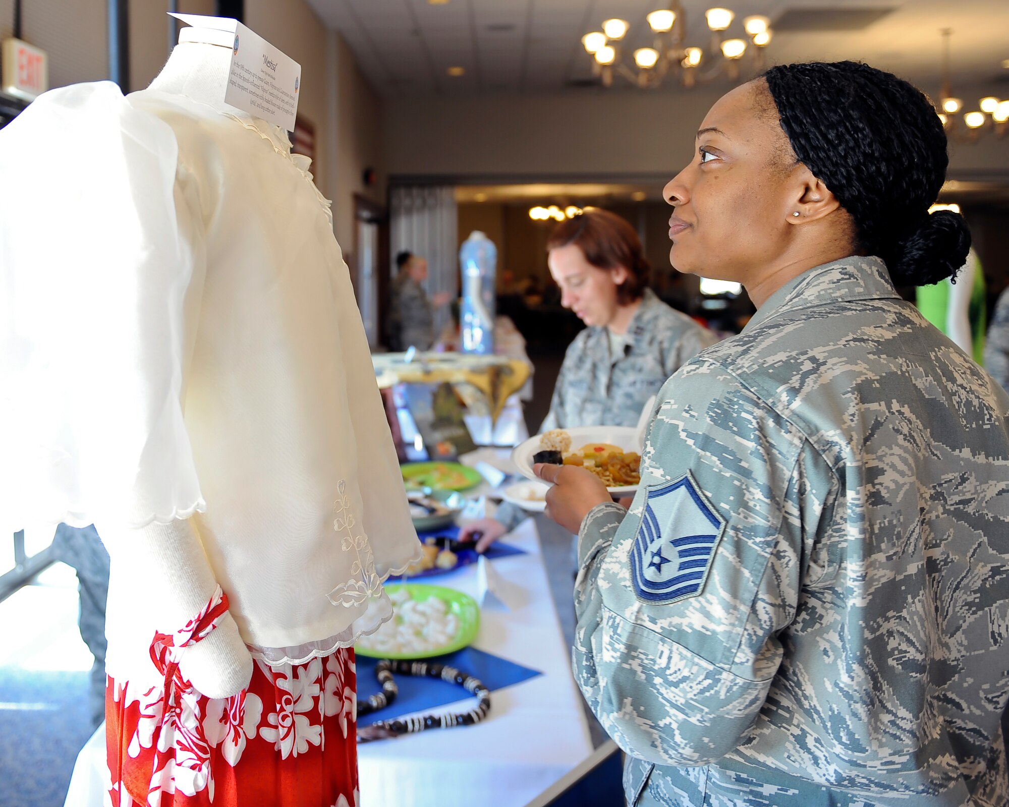 U.S. Air Force Master Sgt. Lashelle Bullock, 7th Aerospace Medicine Squadron medical services flight chief, views a mestiza at the Tour of Asia and the Pacific Islands Art Expo May 8, 2014, at Dyess Air Force Base, Texas. In the 19th century, Filipino and Guamanian women dressed alike in the Spanish-influenced, Filipino-style of dress. The bell-shaped, transparent and intricate blouse is made of pineapple fiber. (U.S. Air Force photo by Airman 1st Class Kedesha Pennant/Released)