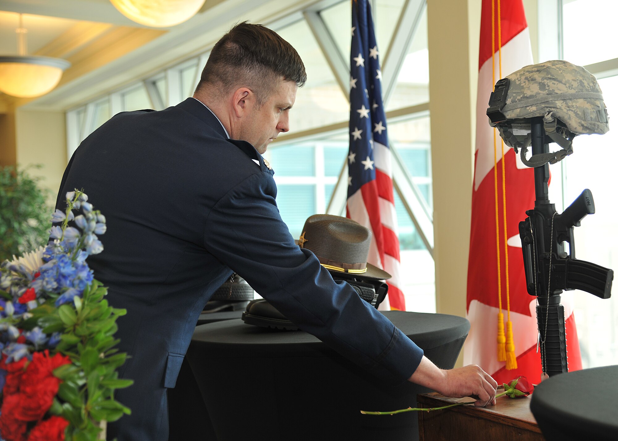 Lt. Col. Jeffery Becker, 319th Security Forces Squadron commander, sets a rose on a fallen warrior memorial during the National Police Week Memorial Service at Grand Forks County District Court on May 13, 2014, in Grand Forks, N.D. The 319th Security Forces Squadron was one of the 11 agencies that attended the event. (U.S. Air Force photo/Senior Airman Xavier Navarro)