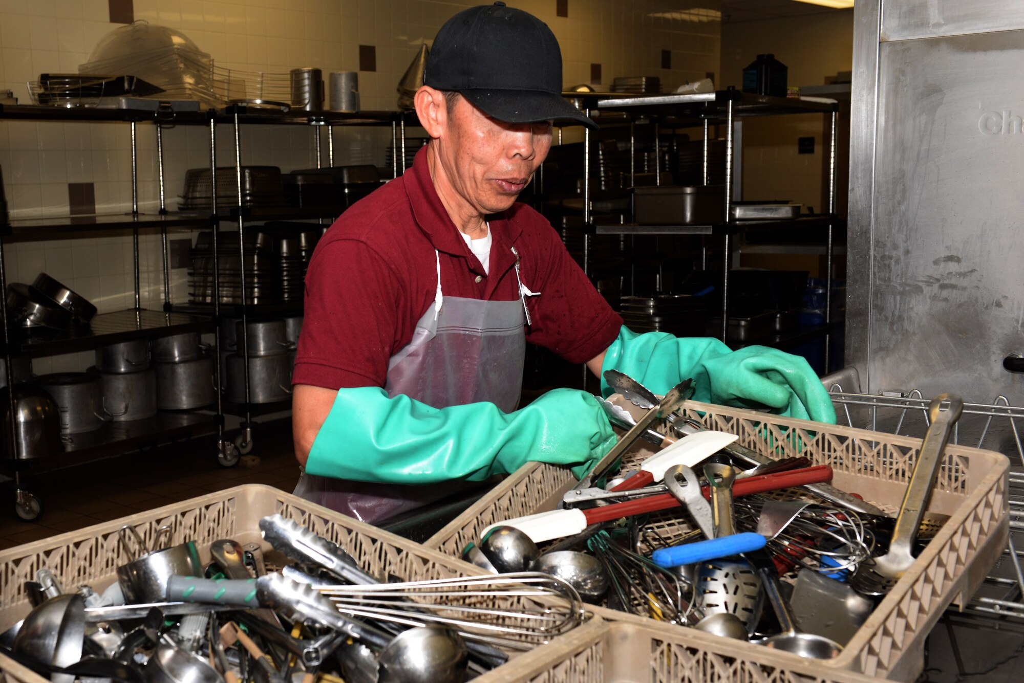 Soeun Khut, a Warriors’ Café employee, cleans serving utensils at Fort Eustis, Va., May 13, 2014. The Warriors’ Café employs 115 workers operating on a 24-hour schedule to accommodate the 128th Aviation Brigade's around-the-clock operations. (U.S. Air Force photo by Senior Airman Teresa J.C. Aber/Released)