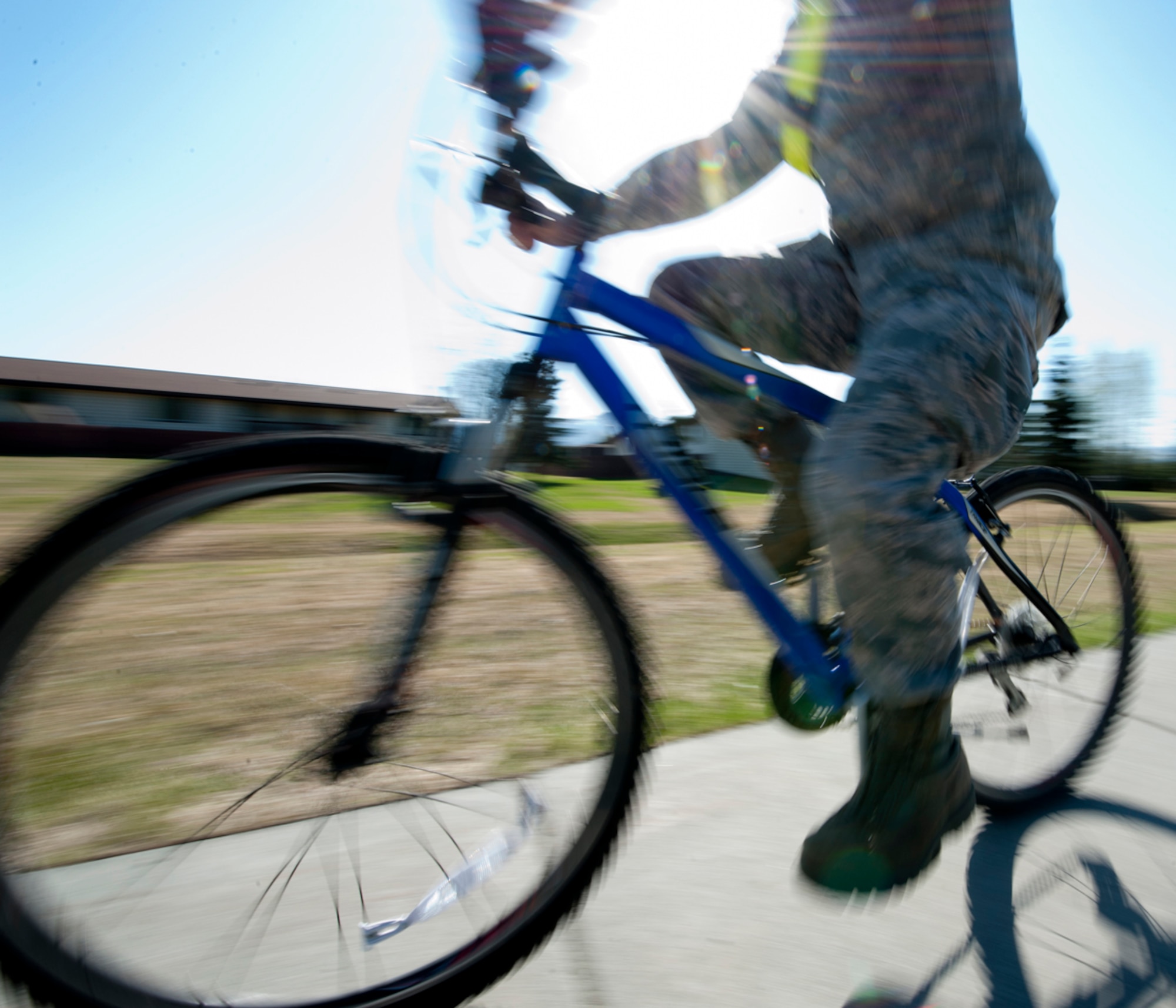 An Airman rides his bicycle to work on Joint Base Elmendorf-Richardson, Alaska, May 10, 2014. Riding a bicycle is one of many physical activities available as part of National Physical Fitness and Sports Month. Bicycling has many benefits such as saving individuals money on gas, getting physically active as they commute, and enjoying the great outdoors. (U.S. Air Force photo/Airman 1st Class Tammie Ramsouer)