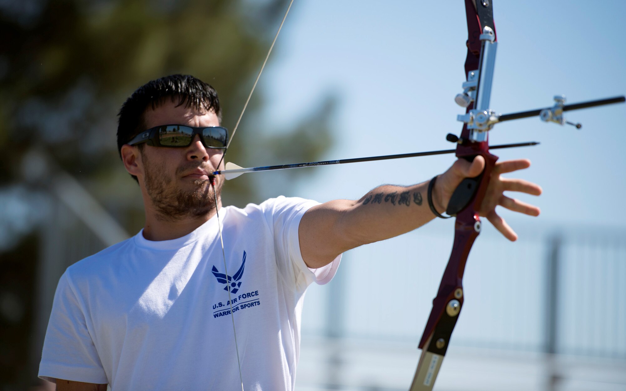Retired Staff Sgt. Daniel Crane draws an arrow back using a mouthpiece during the Air Force Trials April 10, 2014, at Nellis Air Force Base, Nev. After a gunshot wound left his right forearm and hand immobile, Crane immersed himself in adaptive sports, where he has learned new ways to overcome his limitations. (U.S. Air Force photo/Senior Airman Jette Carr)