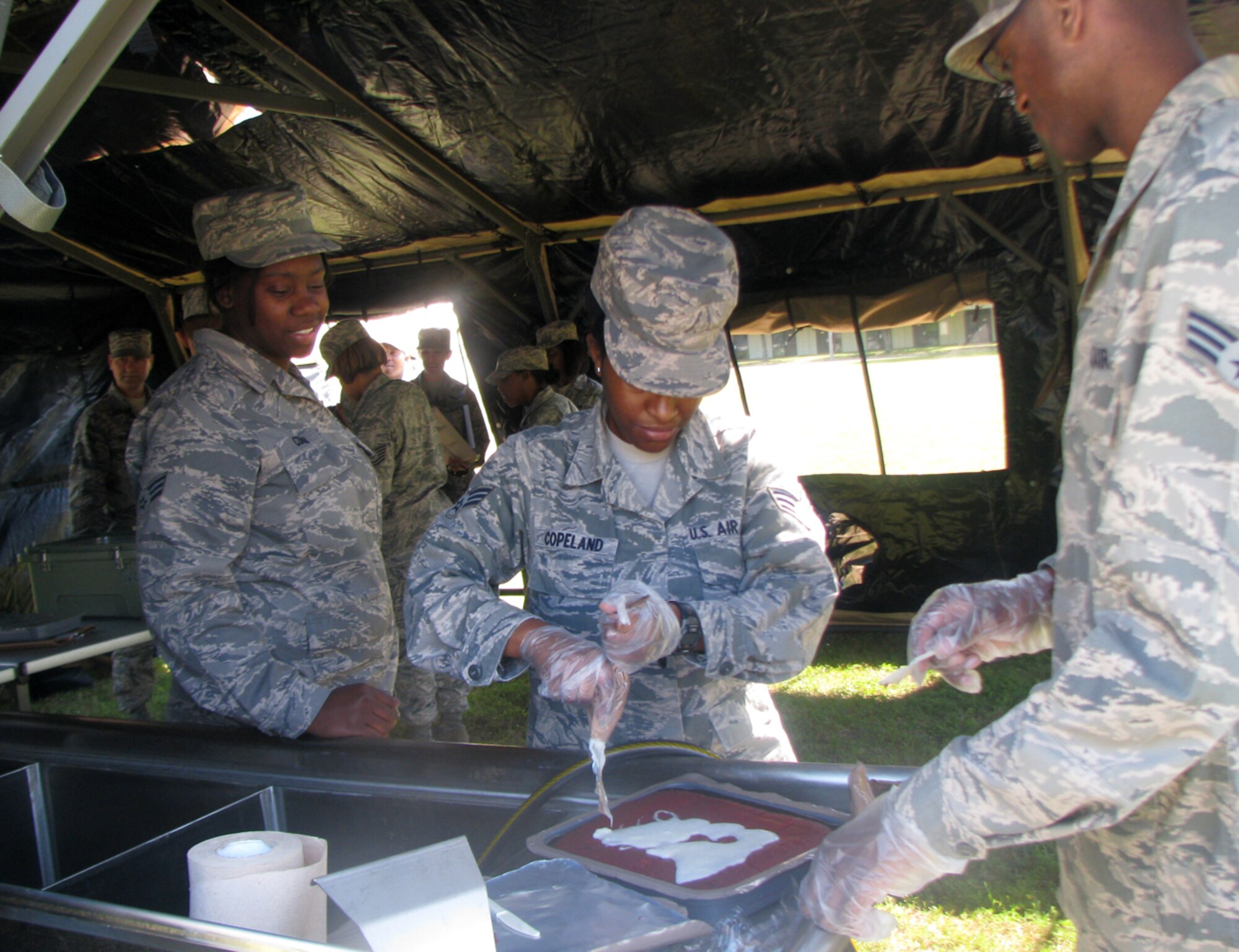 Senior Airman Amanda Copeland, assisted by Senior Airman Eric Coley
and Senior Airman Charphanik Conway, prepared dessert as part of the Single
Pallet Expeditionary Kitchen training here May 3, 2014. Members of the 403rd
Services Sustainment Flight conducted SPEK training at Keesler Air Force Base, Mississippi, May 2-3, 2014 as part of the 403rd Mission Support Group's Functional Area Training Event. (U.S. Air Force photo)