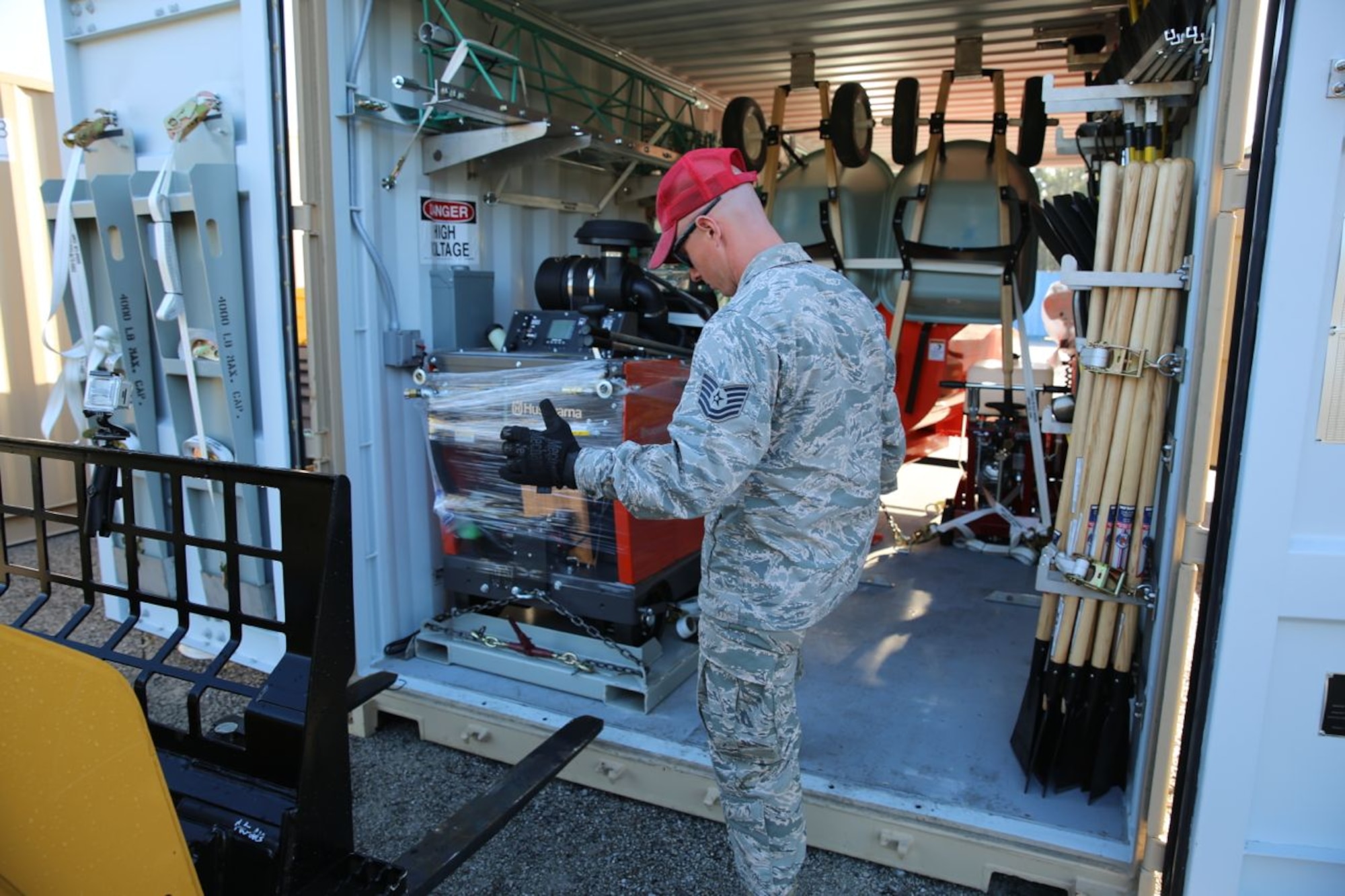 Tech. Sgt. Jason Ward, Detachment 1, 823rd RED HORSE Squadron, directs the extraction of a walk-behind concrete saw during the setup of the sustainment pavement repair kit, or SuPR kit, at the Silver Flag exercise at Tyndall Air Force Base, Fla., on March 11, 2014. The SuPR kit contains more than 350 types of items condensed into five 20-foot shipping containers and includes equipment, tools and materials help Air Force civil engineers repair and sustain deployed airfields. The five containers can be configured into a fully operational pavement repair shop to provide working space for the CEs in a contingency environment. (U.S. Air Force photo/Eddie Green)