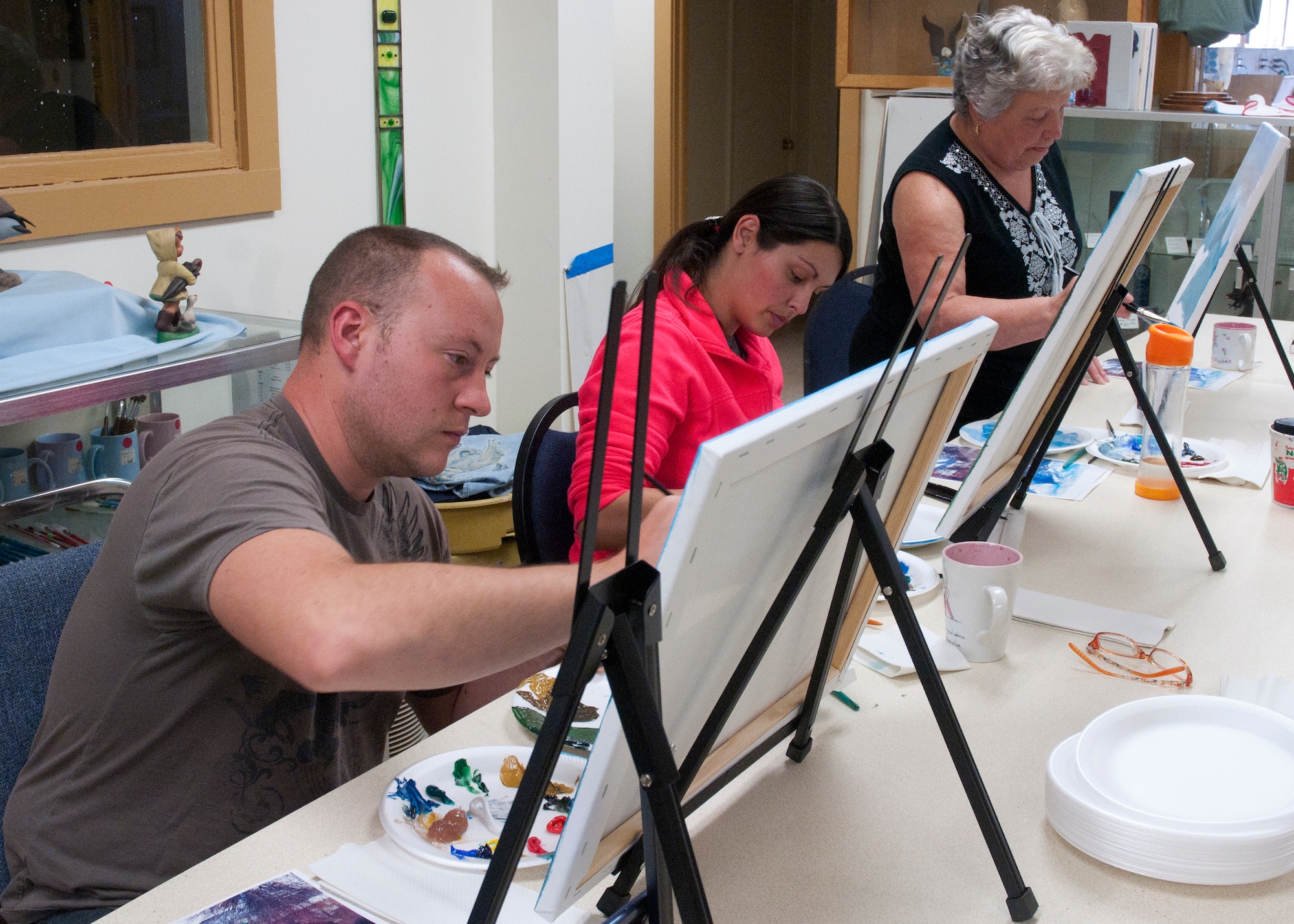 Laura Skoglund, 90th Force Support Squadron, teaches class members about oil painting on canvas at the Arts and Crafts Center May 13. (U.S. Air Force photo by Airman Malcolm Mayfield)