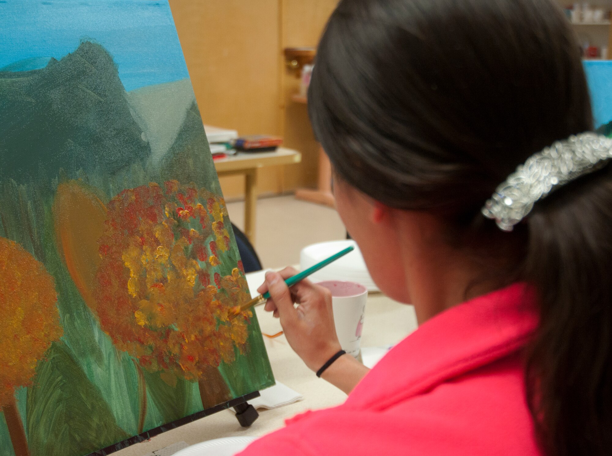 Amanda Wilson, spouse of Sgt. 1st Class Johnathan Wilson, 387th Military Police Indiana National Guard, works on her interpretation of a photo during an oil painting class in the Arts and Crafts Center. During the class, participants were shown a photograph of scenery and instructed to interpret in their painting. (U.S. Air Force photo by Airman Malcolm Mayfield)