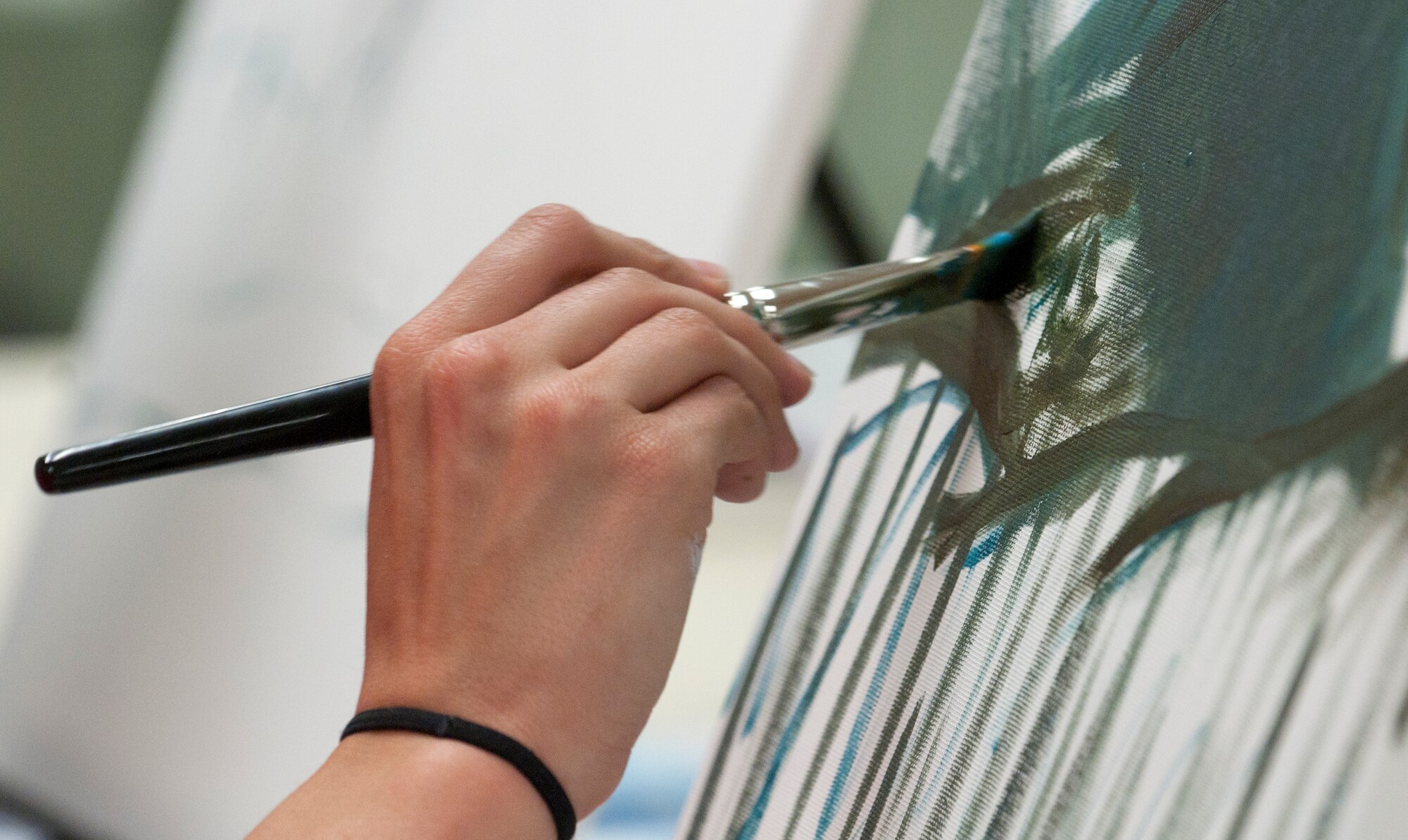 Amanda Wilson, spouse of Sgt. 1st Class Johnathan Wilson, 387th Military Police Indiana National Guard, paints on a canvas May 13 during an oil painting class in the Arts and Crafts Center. (U.S. Air Force photo by Airman Malcolm Mayfield)