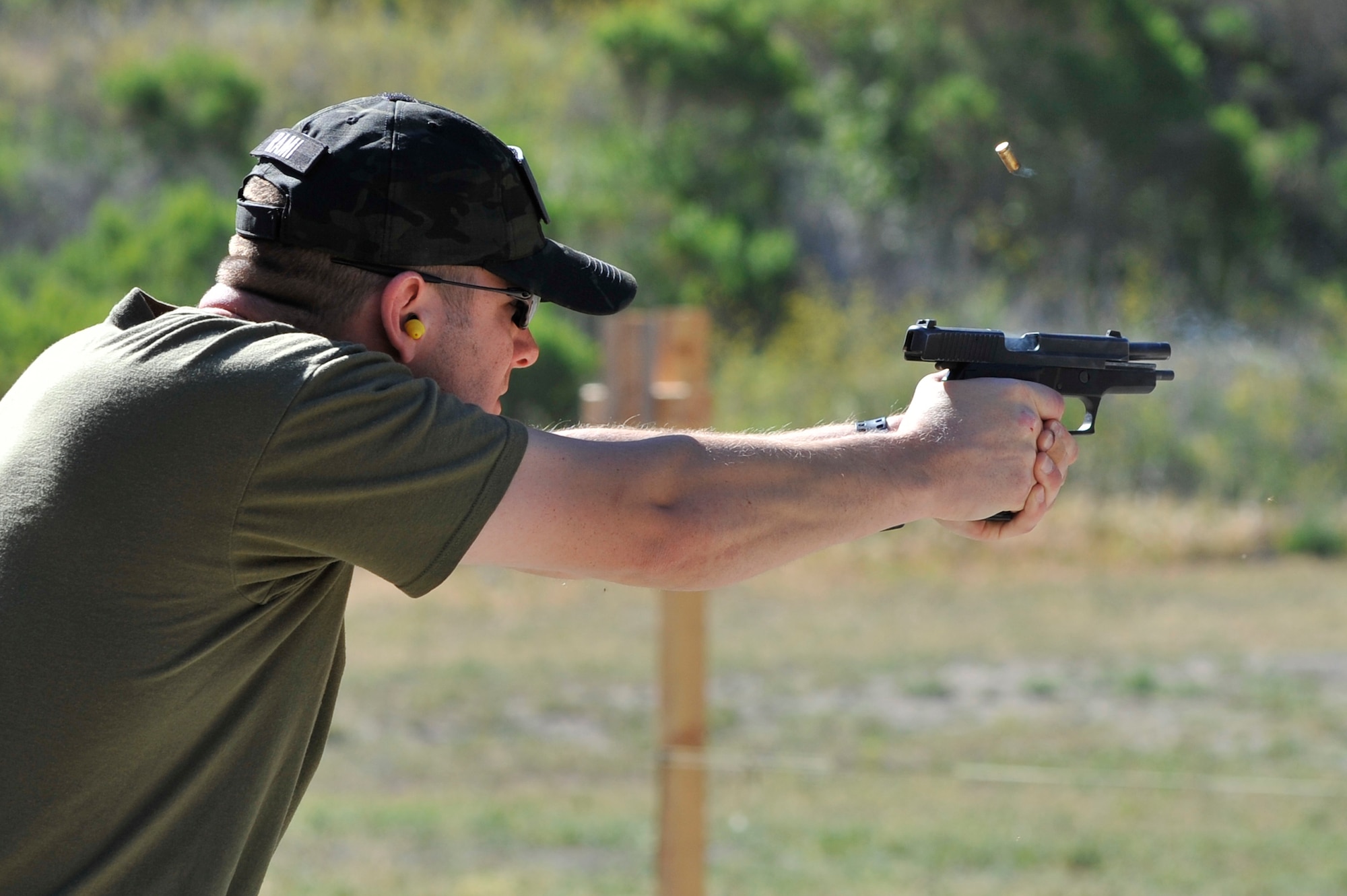 An empty bullet casing is ejected as Tech. Sgt. Ian Ramirez, 30th Security Forces Squadron noncommissioned officer in-charge of supply, fires a round during a shooting challenge at the Law Enforcement Pistol Shoot event May 13, 2014, Vandenberg Air Force Base, Calif. The pistol shoot was open to all military and local law enforcement officers as part of a National Police Week celebration at Vandenberg. (U.S. Air Force photo by Michael Peterson/Released)