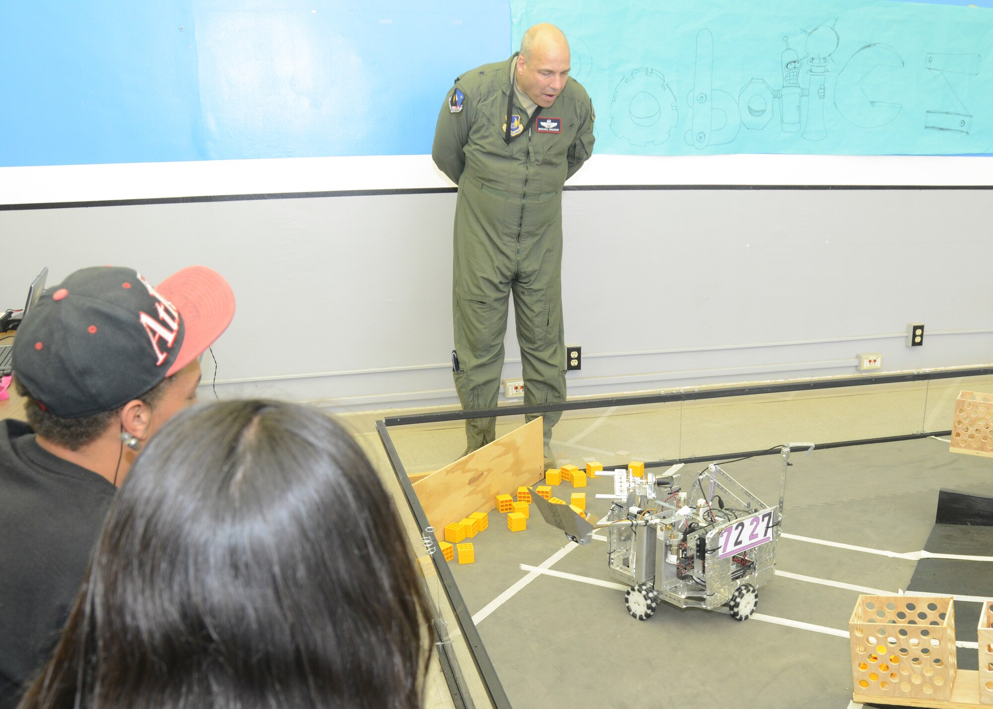As members of the Scorpion Robotics club operate the controls, Brig. Gen. Michael T. Brewer, 412th Test Wing commander, watches the club's Scoop Da Whoop robot scoop up blocks and load them into boxes at the Center of Excellence. Both the Scorpion Robotics and Odyssey of the Minds clubs held an open house. Both are looking for coaches, volunteers and mentors. (U.S. Air Force photo by Kenji Thuloweit) 