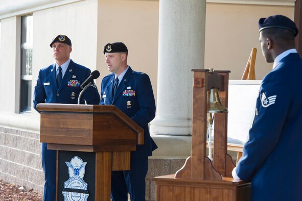 Maj. Nathan Puwalowski, 45th Security Forces Squadron commander and presiding official, shares his speech with the audience during the Fallen Heroes Ceremony at Patrick Air Force Base, Fla. May 13, 2014. Since the first known line of duty death in 1791, more than 19,000 American law enforcement officers have made the ultimate sacrifice. Also photographed are two 45th SFS Staff Sgts. Michael Blackmon (far left) and Xavier Henderson (right), who played a role in the ceremony. (U.S. Air Force photo/Matthew Jurgens) 