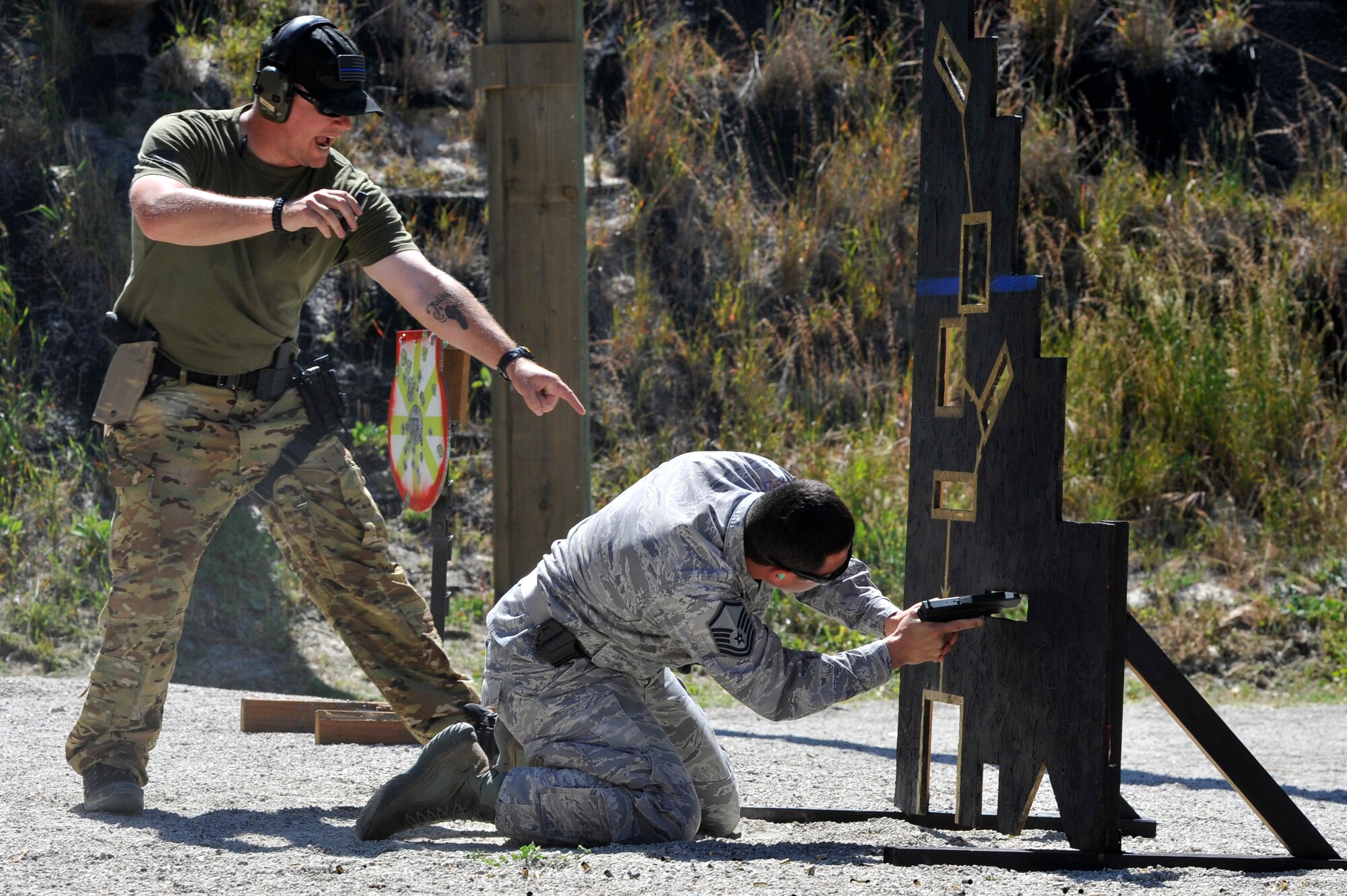 Range safety officer SSgt Daniel Kane, 30th Security Forces Squadron patrolman, directs a competitor towards his next shot of a shooting course during the Law Enforcement Pistol Shoot event May 13, 2014, Vandenberg Air Force Base, Calif. The pistol shoot was open to all military and local law enforcement officers as part of a National Police Week celebration at Vandenberg. (U.S. Air Force photo by Michael Peterson/Released)