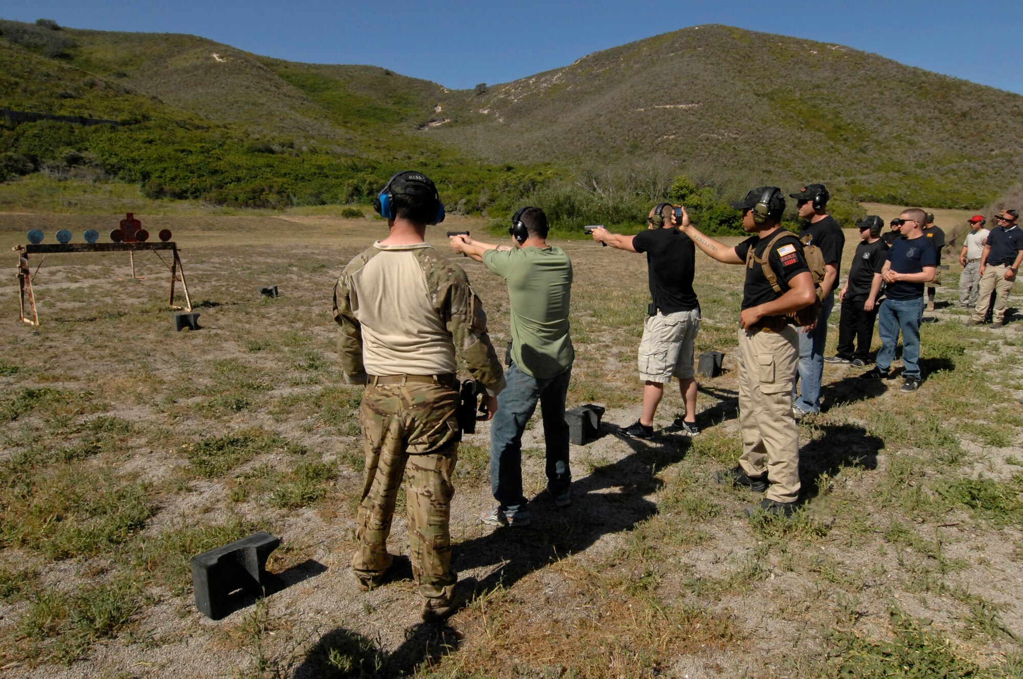 Competitors take aim at a series of three targets during a one-on-one shooting challenge at the Law Enforcement Pistol Shoot event May 13, 2014, Vandenberg Air Force Base, Calif. The pistol shoot was open to all military and local law enforcement officers as part of a National Police Week celebration at Vandenberg. (U.S. Air Force photo by Michael Peterson/Released)
