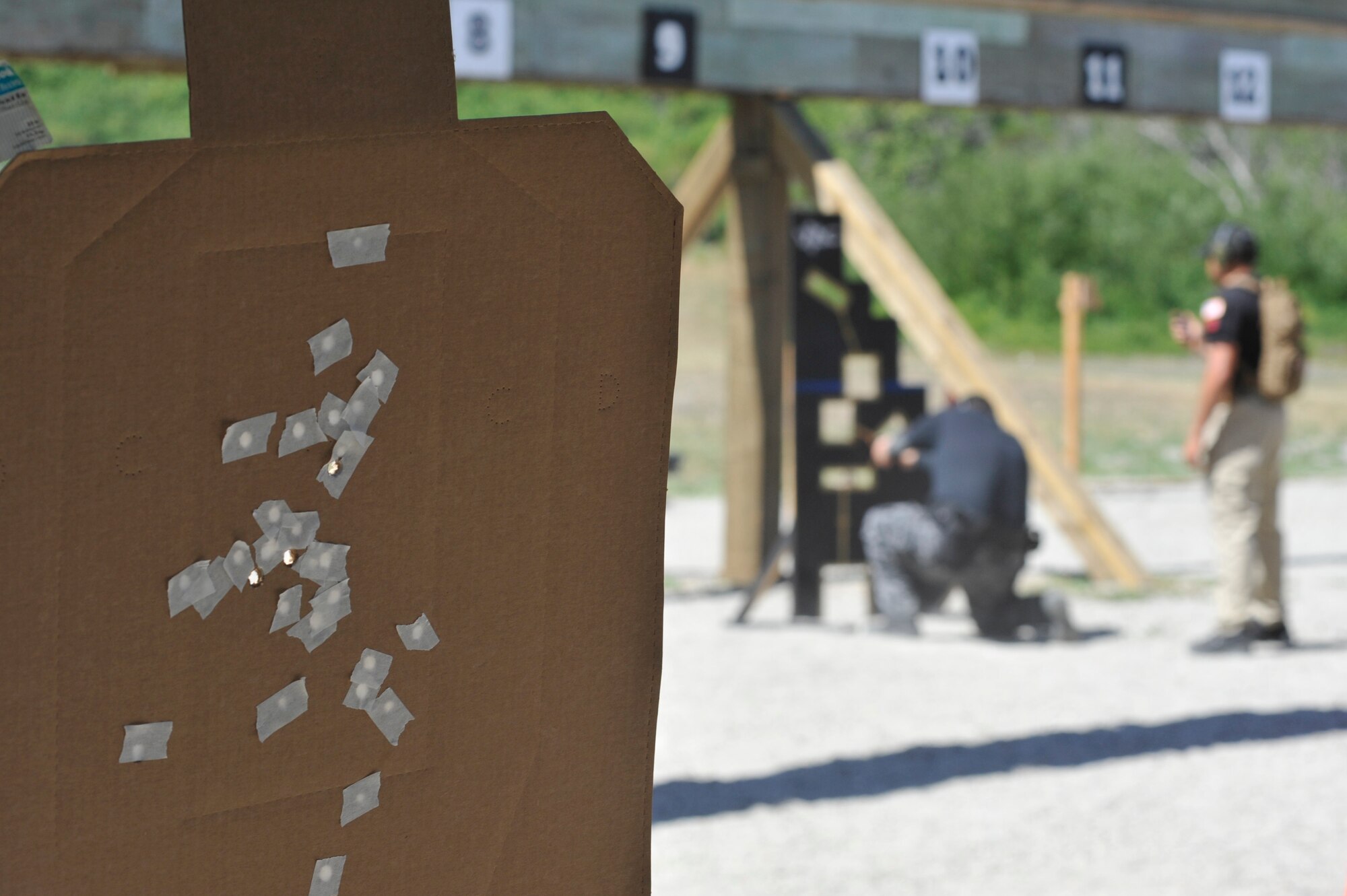 Three fresh bullets holes are left on a cardboard target as their creator completes the next stage of a shooting course at the Law Enforcement Pistol Shoot event May 13, 2014, Vandenberg Air Force Base, Calif. The pistol shoot was open to all military and local law enforcement officers as part of a National Police Week celebration at Vandenberg. (U.S. Air Force photo by Michael Peterson/Released)
