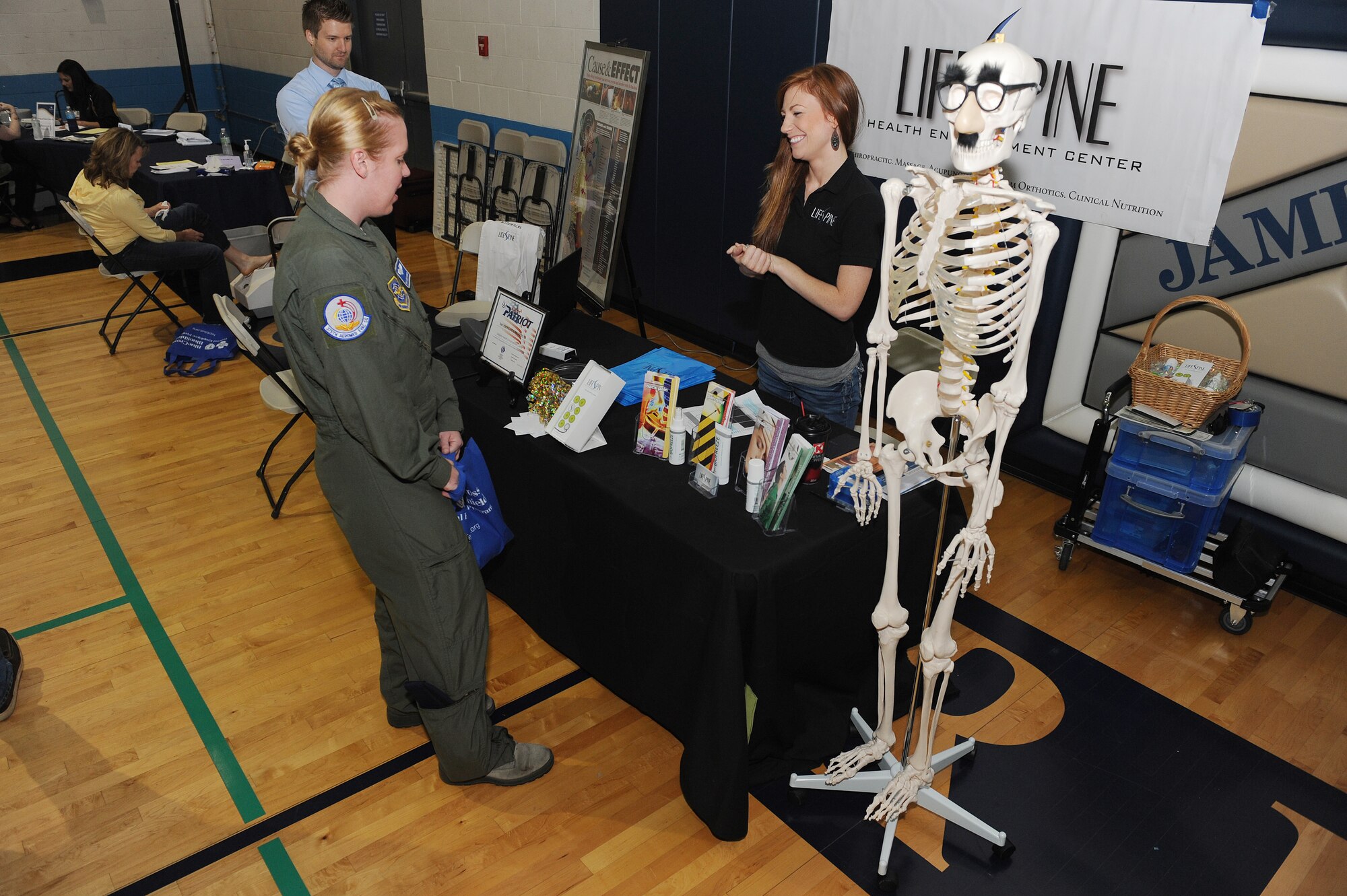 Tracy Currier talks to a guest about her back health during the fitness fair at Scott Air Force Base, Ill., May 9, 2014. Patrons of the fair met with 30 vendors and discussed health and fitness related topics. Some vendors included nurses from a local hospital, who checked people’s blood pressure, glucose and cholesterol levels, and bone density. The fair had raffles, giving away prizes, including baseball tickets and gift certificates.  (U.S. Air Force photo/Staff Sgt. Maria Bowman)