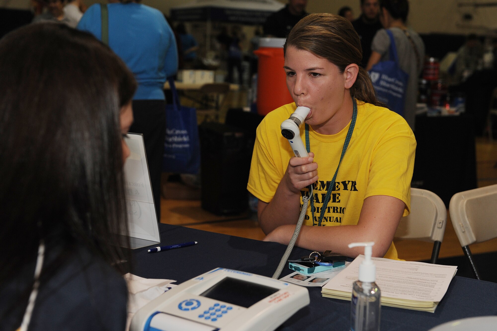 Alicia Becker completes a forced vital capacity test during the fitness fair at Scott Air Force Base, Ill., May 9, 2014.  During the test, patients seal their lips around the mouthpiece, and after inhaling as much as they can, they exhale fully, as hard as they can, for at least six seconds, followed by deeply inhaling.  This tests a person’s lung function and the amount of air a person can exhale with force.  Becker is a Defense Information Technology Contracting Organization contract specialist.  (U.S. Air Force photo by Staff Sgt. Maria Bowman)