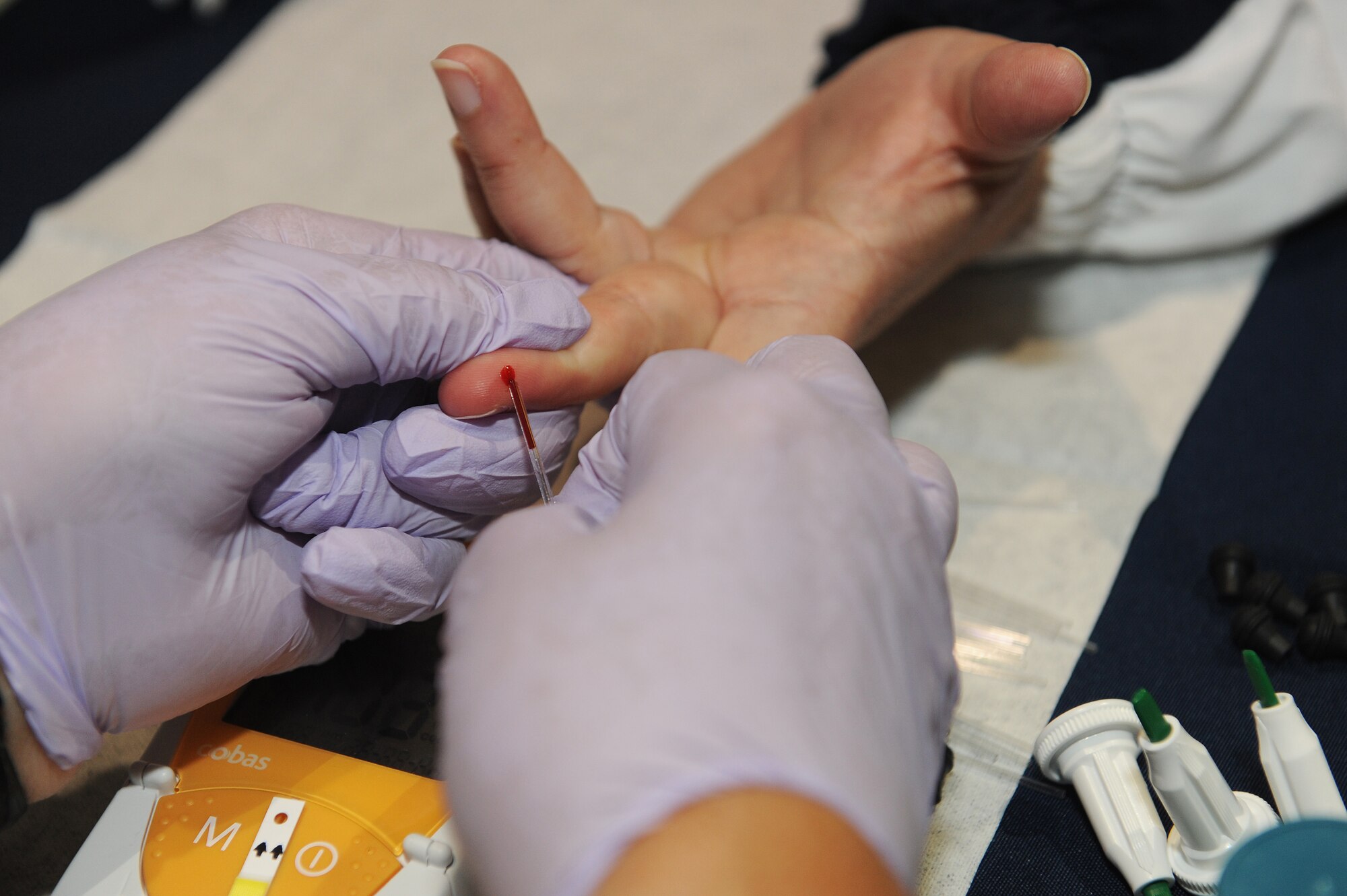 A visitor of the fitness fair has her cholesterol and glucose levels checked at Scott Air Force Base, Ill., May 9, 2014.  During the fitness fair, guests were also invited to check their blood pressure, bone density, and breathing capabilities.  Other vendors included local dentists, chiropractors, running stores, and health stores. (U.S. Air Force photo/Staff Sgt. Maria Bowman)