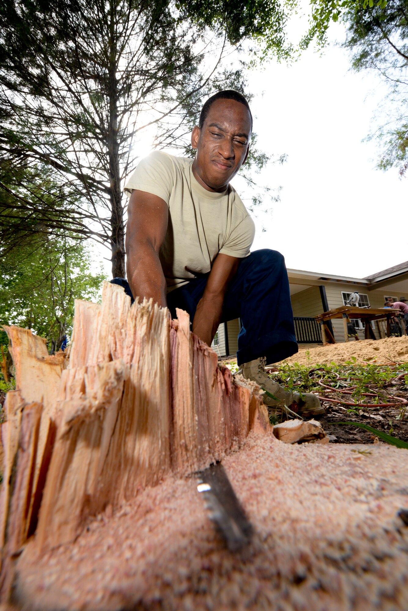 U.S. Air Force Staff Sgt. Rodric Peterson, 23d Aerospace Medical Squadron, uses a saw to cut a tree stump during a Habitat for Humanity build in Ray City, Ga., May 10, 2014. Peterson and other volunteers had a variety of tasks to complete during the build, ranging from building porch railings to clearing the yards from any unwanted vegetation. (U.S. Air Force photo by Tech. Sgt. Joshua J. Garcia/Released)