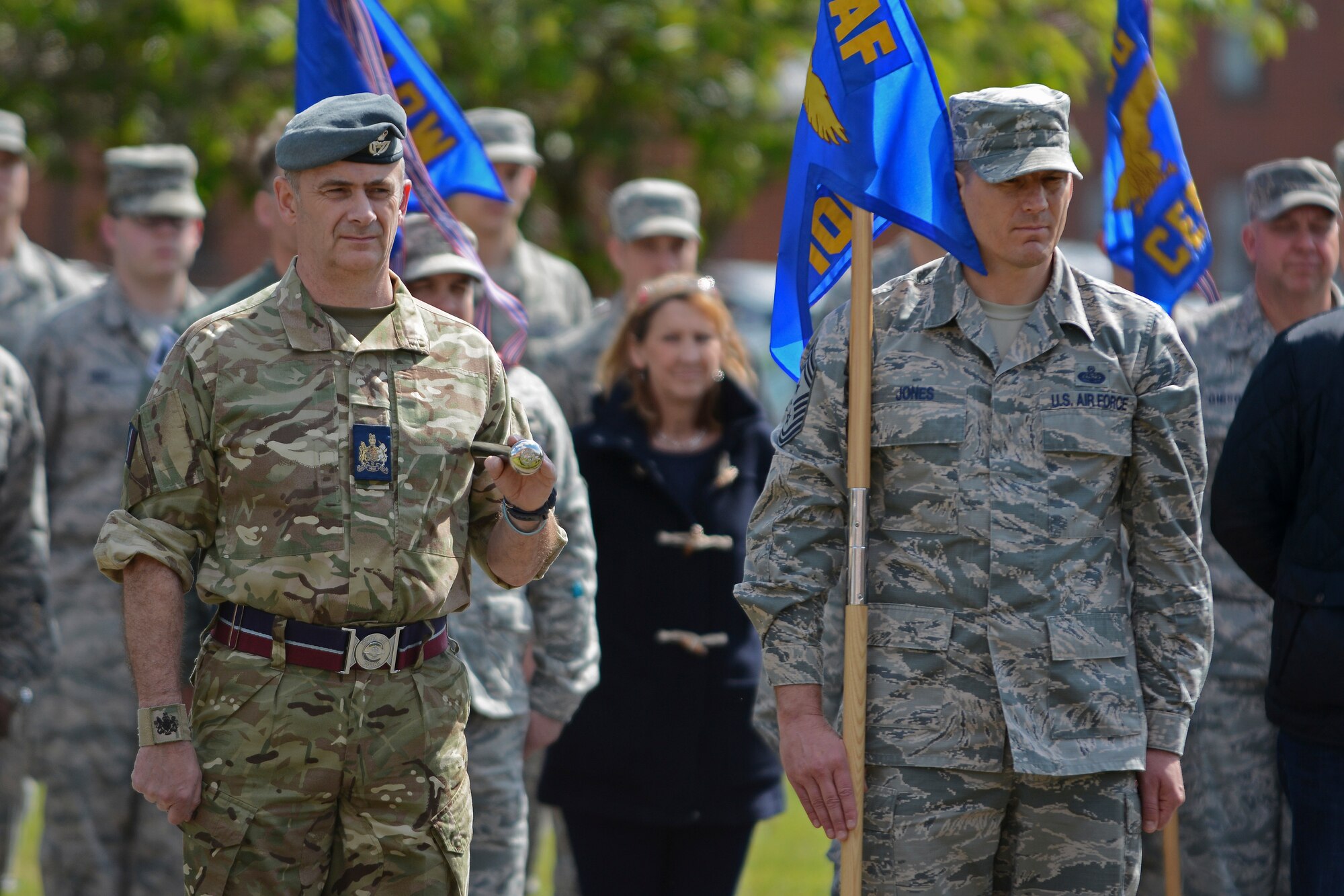 Royal Air Force Warrant Officer Steve Roberts, left, RAF Marham station warrant officer, and U.S. Air Force Chief Master Sgt. Tracy Jones, 100th Air Refueling Wing command chief, stand at attention during a retreat ceremony for Honorary Commanders’ Day May 13, 2014, on RAF Mildenhall, England. Throughout the day, honorary commanders and their sponsors participated in a competitive team building event, viewed aircraft and met with Airmen. (U.S. Air Force photo by Senior Airman Micaiah Anthony/Released)