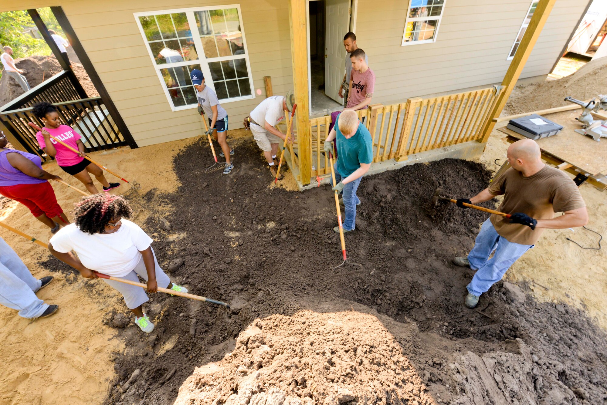 Airmen from Moody Air Force Base, Ga., and members of the local community help spread dirt during a Habitat for Humanity build in Ray City, Ga., May 10, 2014. Through volunteers Habitat for Humanity helps thousands of low-income families by building new affordable homes for them to live in. (U.S. Air Force photo by Tech. Sgt. Joshua J. Garcia/Released) 