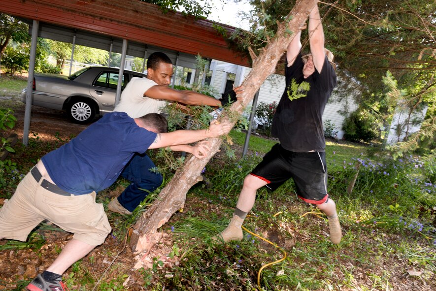 Airmen from Moody Air Force Base, Ga., bring down a tree during a Habitat for Humanity build in Ray City, Ga., May 10, 2014. During the build Team Moody helped build porch railings, clear the yards of any unwanted vegetation and spread dirt evenly to be the foundation for the yard. (U.S. Air Force photo by Tech. Sgt. Joshua J. Garcia/Released) 
