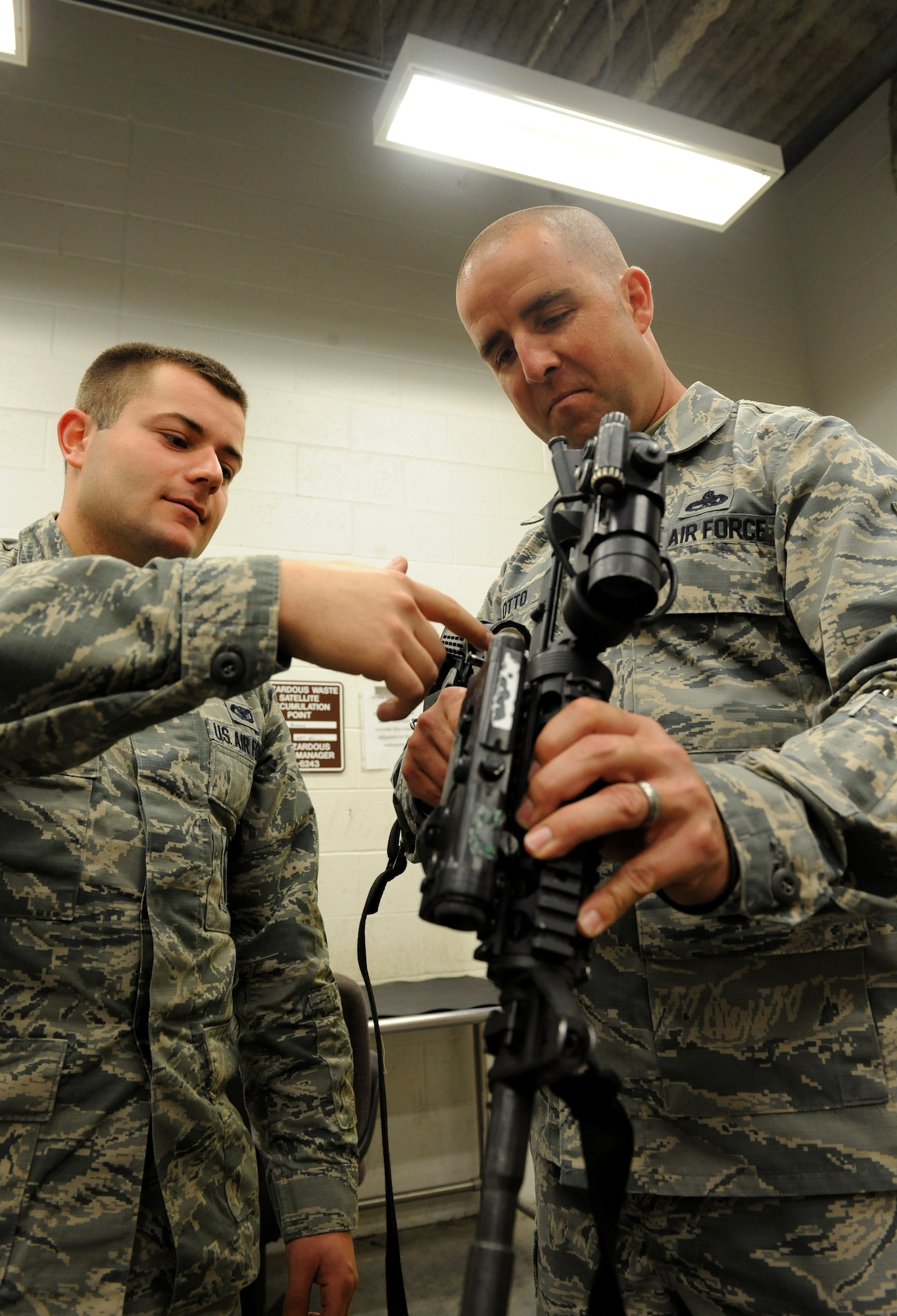Master Sgt. Trapper Otto, 509th Security Forces Squadron first sergeant, and Senior Airman Matthew Stivala, 509th Security Forces Squadron response force member, inspect an M-4 rifle at Whiteman Air Force Base, Mo., May 1, 2014. U.S. Air Force first sergeants are responsible for the morale, welfare and well-being of the enlisted members of their respective squadrons.(U.S Air Force photo by Airman 1st Class Joel Pfiester/Released)