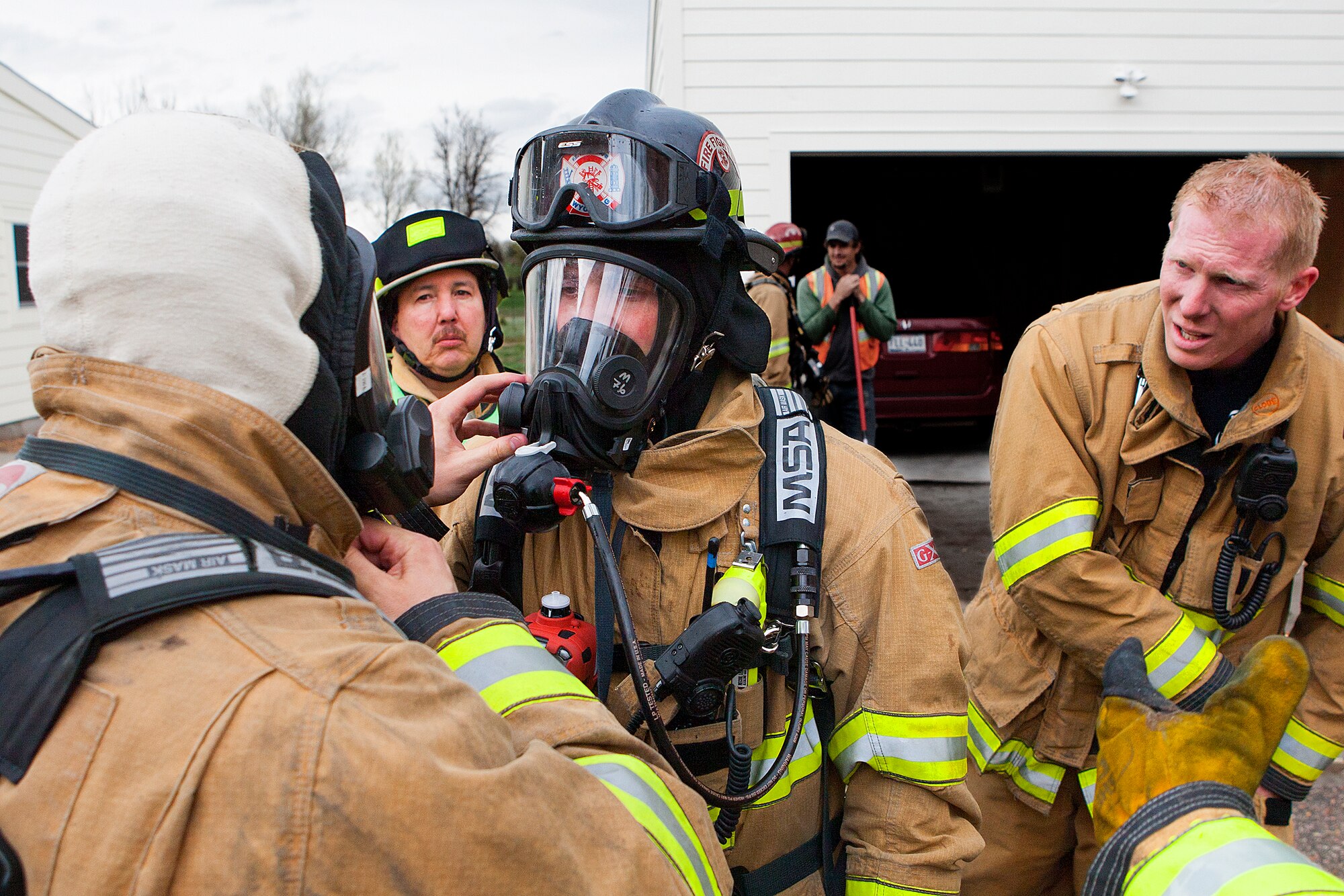 140507-F-JW079-122
Senior Airman Justin Rhine, 90th Civil Engineer Squadron firefighter, gets his air mask checked prior to entering a house that has a natural-gas leak May 7, 2013. Ronnie Riedel, the on scene safety officer, and firefighter Joshua Sarters look on. The gas leak was a result of the damage caused by a lightning strike. Rhine and other firefighters were preparing to enter the home to retrieve family pets. (U.S. Air Force photo by R.J. Oriez)
