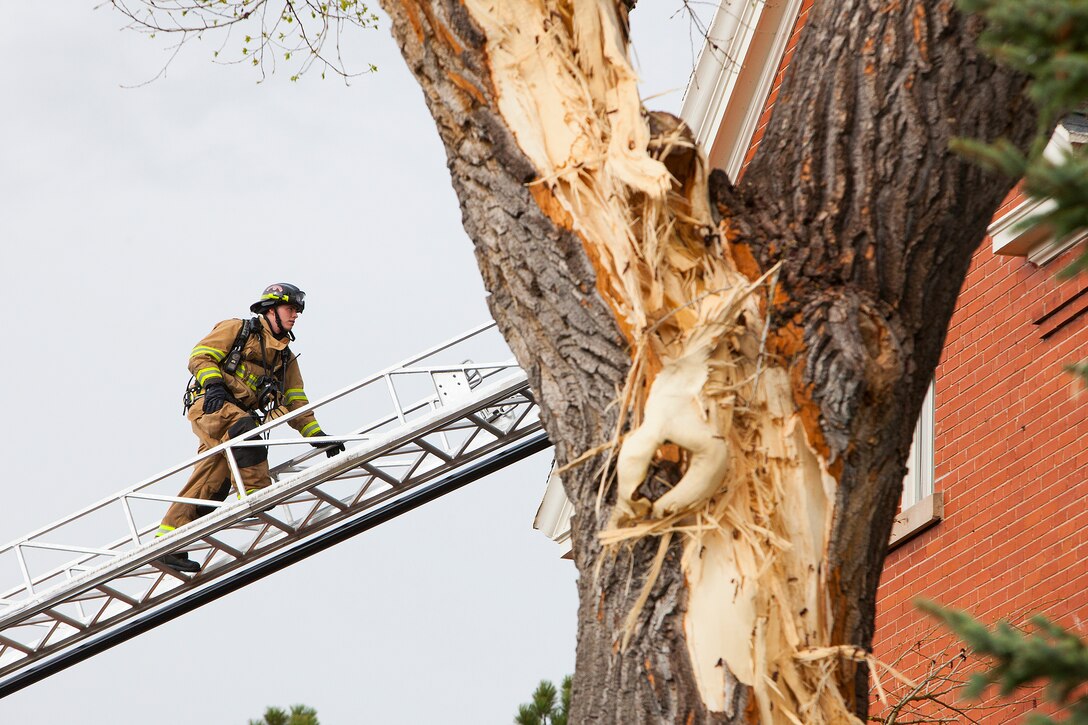 140507-F-JW079-069
Airman 1st Class James Deluca, 90th Civil Engineer Squadron firefighter, climbs a ladder up to the roof of Quarters 110 on F.E. Warren Air Force Base May 7, 2013 to help inspect for damage following a lightning strike. Lightning struck the tree in the foreground and then found its way into the house through the plumbing system. (U.S. Air Force photo by R.J. Oriez)
