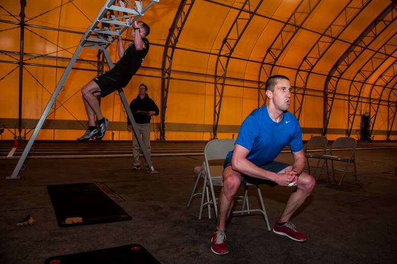 Pete Forde (right), 50th Contracting Squadron, performs squats during “The Murph” competition May 9, 2014, at Schriever Air Force Base, Colo. The competition is part of the Schriever Fitness Center’s May Fitness Month activities. Participants who completed “The Murph” in under an hour earned an event T-shirt. (U.S. Air Force photo/Staff Sgt. Julius Delos Reyes)