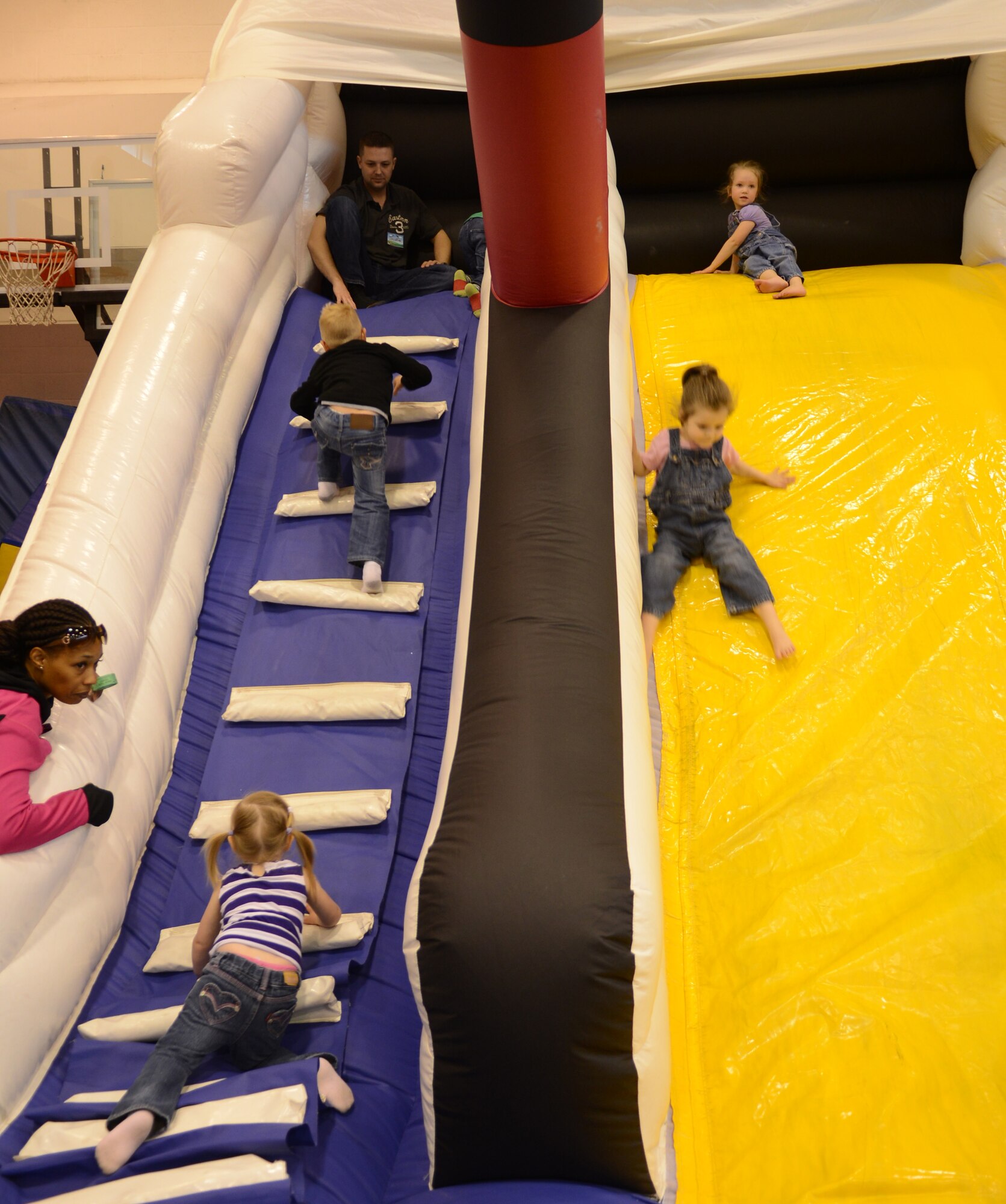 Team Mildenhall children play on an inflatable slide May 10, 2014, during a spring fun day at the youth center on RAF Mildenhall, England. The day included barbecued food, play areas for children and a K-9 demonstration from the 100th Security Forces Squadron. (U.S. Air Force photo by Airman 1st Class Dillon Johnston/Released)