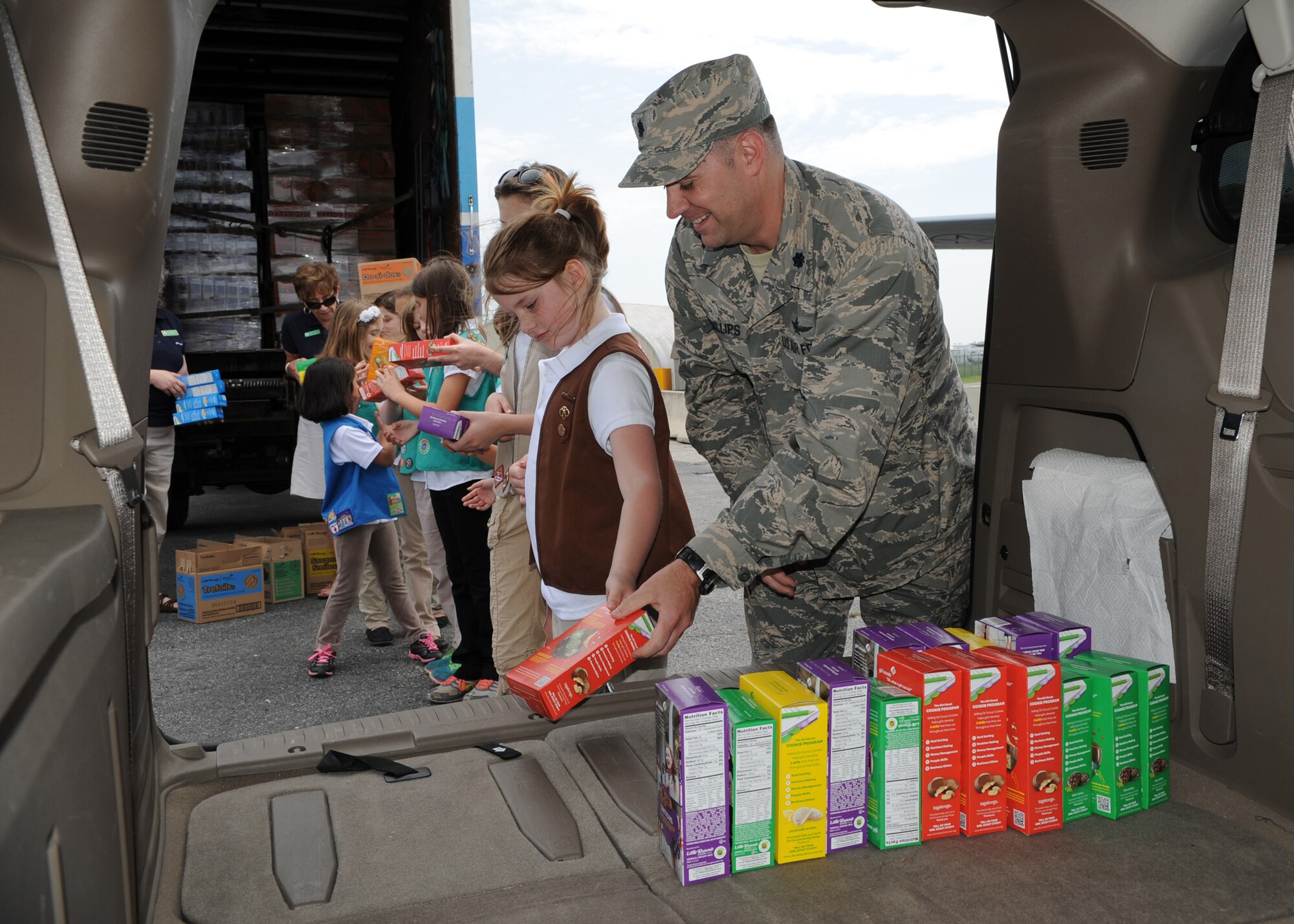 Lt. Col. Michael Phillips, 436th Airlift Wing Mission Support Group deputy commander and Girl Scouts from throughout the Delmarva Peninsula load boxes of cookies into a van May 13, 2014 at the Air Mobility Command Museum on Dover Air Force Base, Del. This is the 11th year that the Chesapeake Bay Girl Scouts Council has donated cookies for Operation Taste of Home. (U.S. Air Force photo/Staff Sgt. Elizabeth Morris)