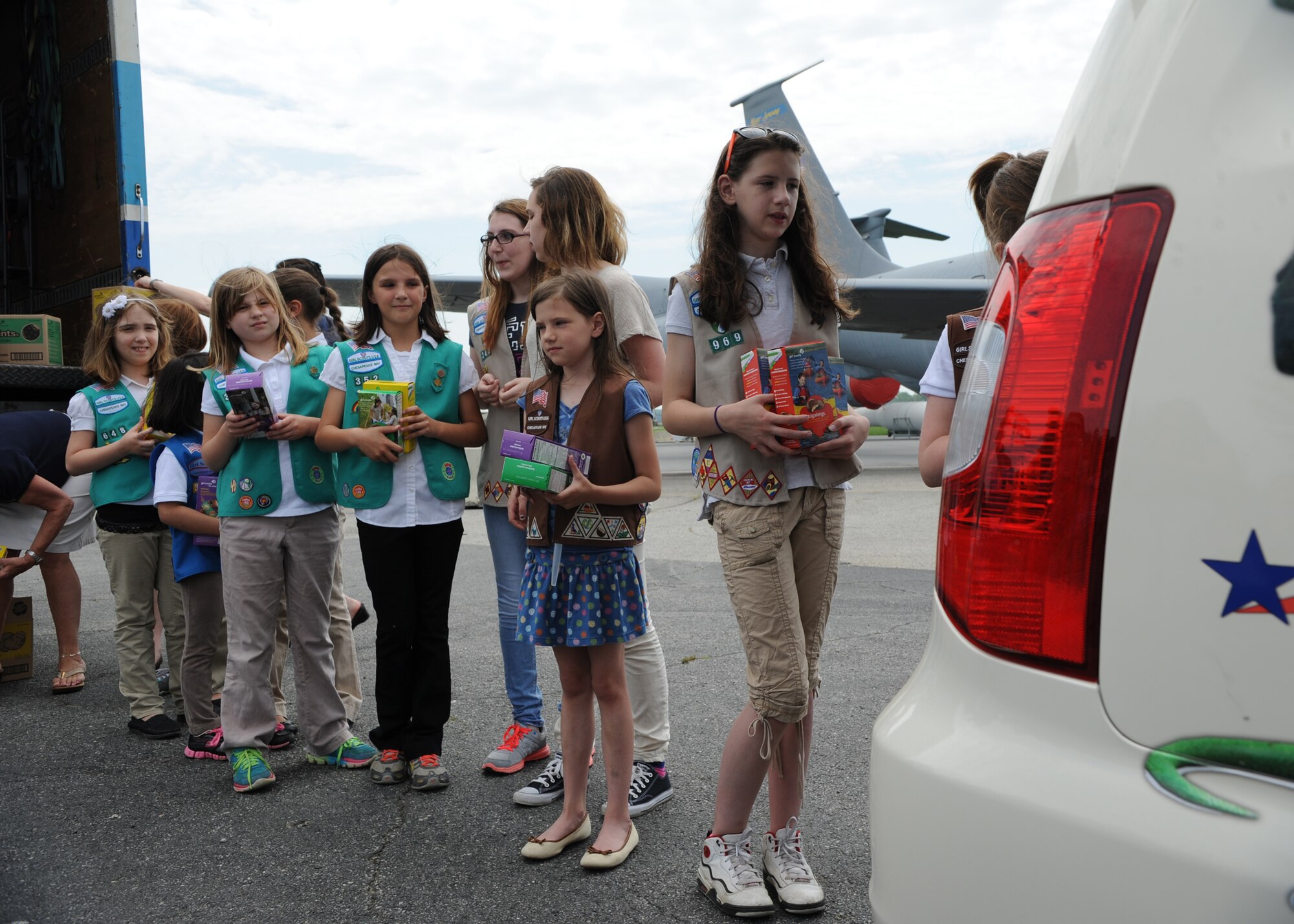 Girl Scouts from throughout the Delmarva Peninsula form a human chain to load boxes of cookies into a van May 13, 2014 at the Air Mobility Command Museum on Dover Air Force Base, Del. The Girl Scouts delivered the cookies to USO Delaware as part of Operation Taste of Home cookie drop that supports military members worldwide. (U.S. Air Force photo/Staff Sgt. Elizabeth Morris)
