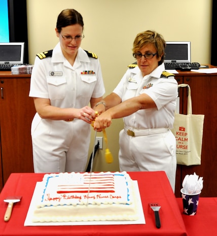Lt. Erin Curtis and Capt. Alice Cagnina, Naval Health Clinic Charleston nurses, cut a cake in honor of the Navy Nurse Corps birthday during a celebration May 13, 2014 at NHCC on Joint Base Charleston.  President Theodore Roosevelt signed the Naval Appropriations Bill authorizing the establishment of the Nurse Corps as a unique staff corps of the Navy May 13, 1908. (U.S. Photo by Petty Officer 1st Class Josh Gutierrez)