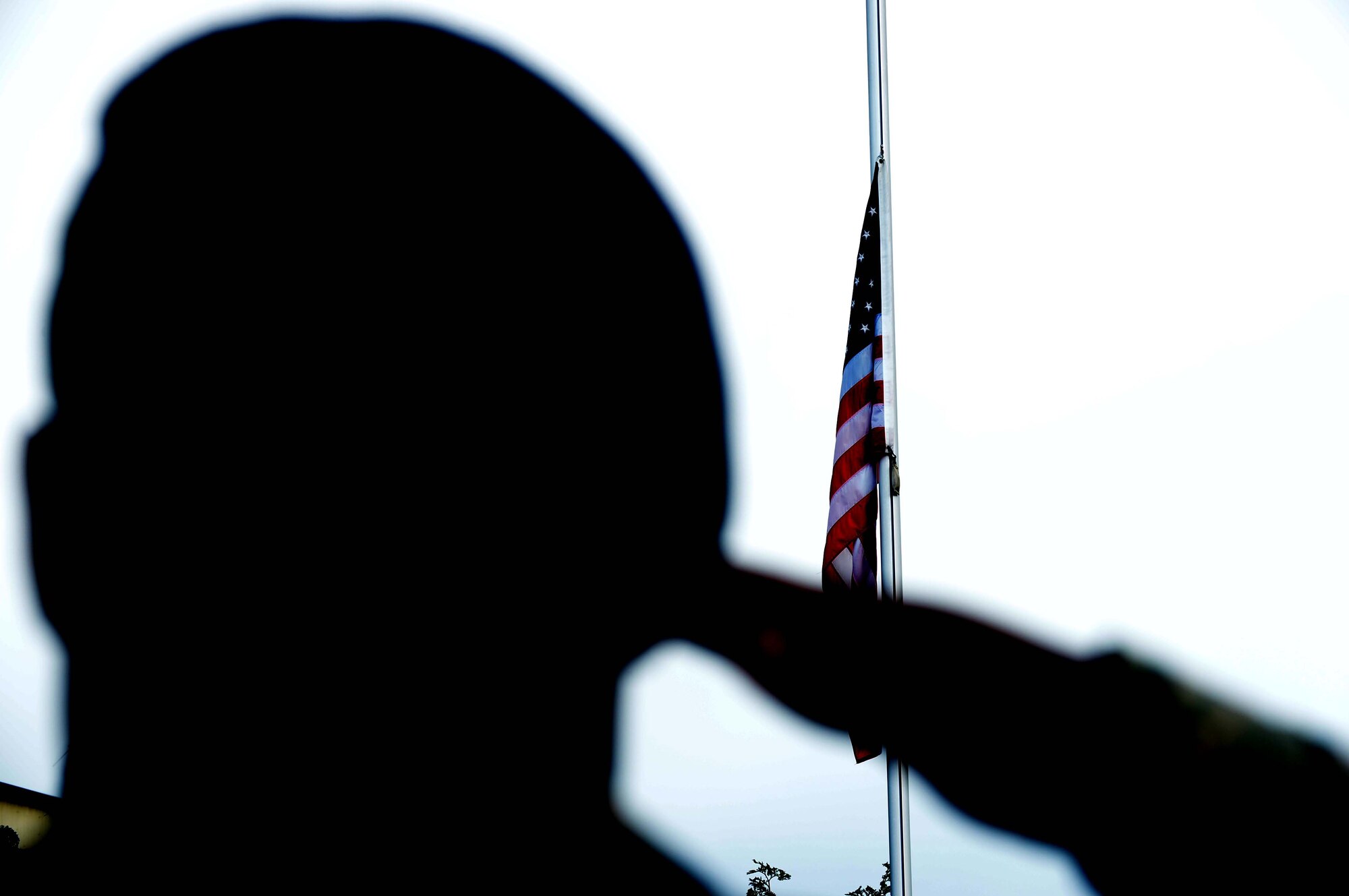 A U.S. Air Force Airman salutes the U.S. flag as it descends during a National Police Week retreat ceremony at Spangdahlem Air Base, Germany, May 12, 2014. The retreat ceremony included a 21-gun salute and the playing of taps. (U.S. Air Force photo by Airman 1st Class Kyle Gese/Released) 