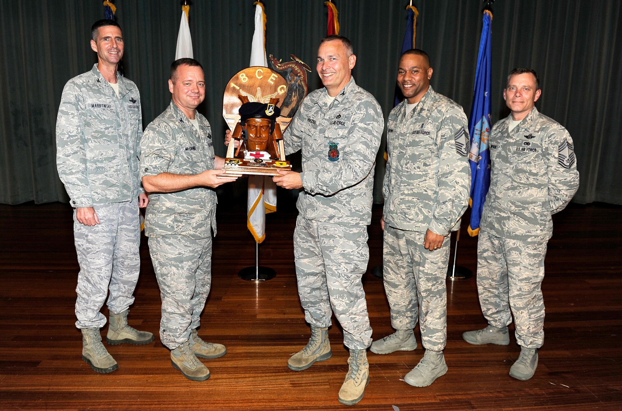 U.S. Air Force Col. Brian McDaniel, 18th Wing vice commander, presents the spirit award to Col. Gary Schneider on behalf of the 18th Civil Engineer Group during the Team Kadena first quarter awards ceremony on Kadena Air Base, Japan, May 9, 2014. The award is given to the Team Kadena unit who showed the most ?spirit? during the ceremony. (U.S. Air Force photo by Senior Airman Maeson L. Elleman)