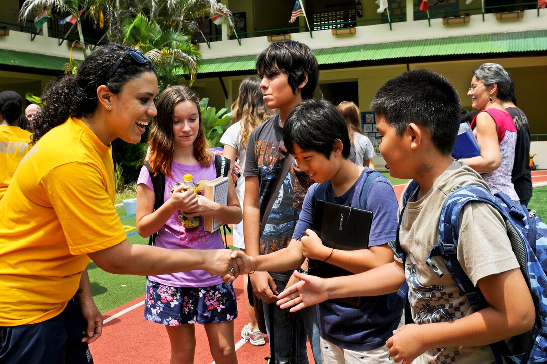 A U.S. sailor assigned to the aircraft carrier USS Nimitz greets students at Quality Schools International during a community service project in Phuket, Thailand, May 31, 2013. The Nimitz is deployed to the U.S. 7th Fleet area of responsibility conducting maritime security operations and theater security cooperation efforts. 
