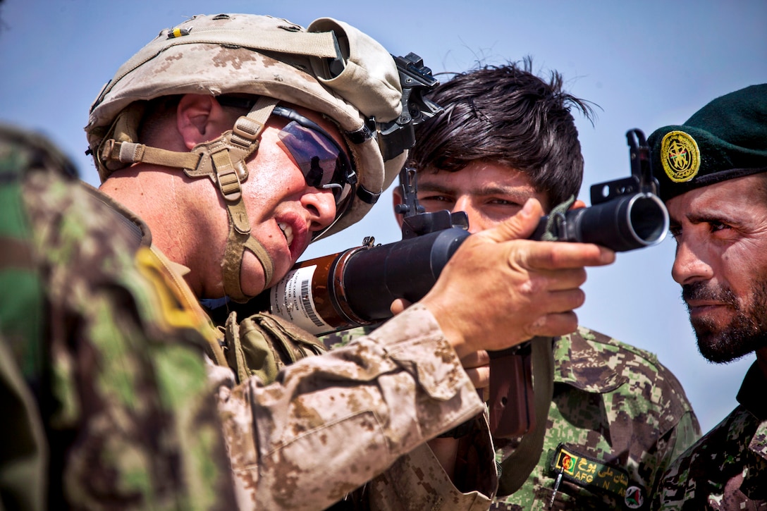 U.S. Marine Corps Staff Sgt. Mark Oeser, left, teaches Afghan soldiers different weapon systems during a live-fire exercise near Camp Shorabak in Afghanistan's Helmand province, May 20, 2013. 
