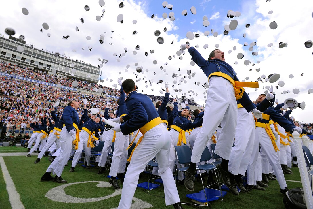Newly commissioned 2nd Lieutenants of the U.S. Air Force Academy's Class of 2013 toss their hats in the air as the Texas Flying Legends Museum, based out of Ellington Field, Texas, provide graduation ceremony fly-by support at Falcon Stadium in Colorado Springs, Colo., May 29, 2013. 
