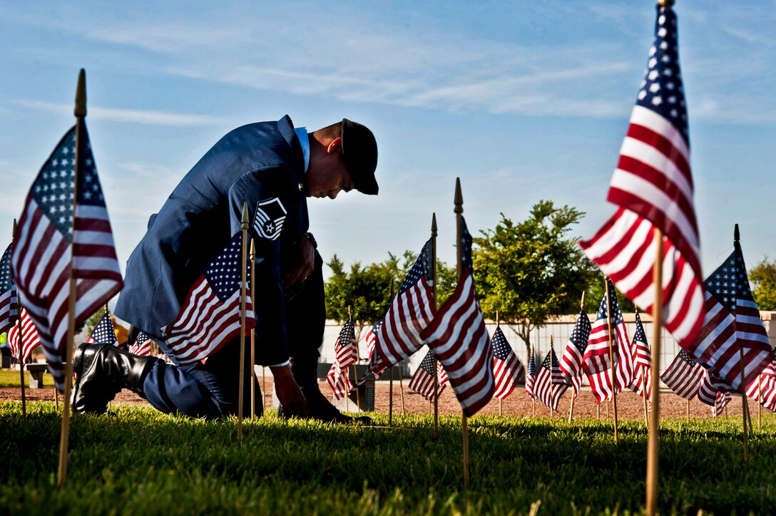 Air Force Master Sgt. Robert Lilly pays his respects to a fallen veteran at the Southern Nevada Veterans Memorial Cemetery in Boulder City, Nev., May 25, 2013. Lilly, a joint tactical air controller assigned to the 57th Operations Group, and other airmen from Nellis Air Force Base, Nev., volunteered their time to place flags at graves for Memorial Day weekend.  
