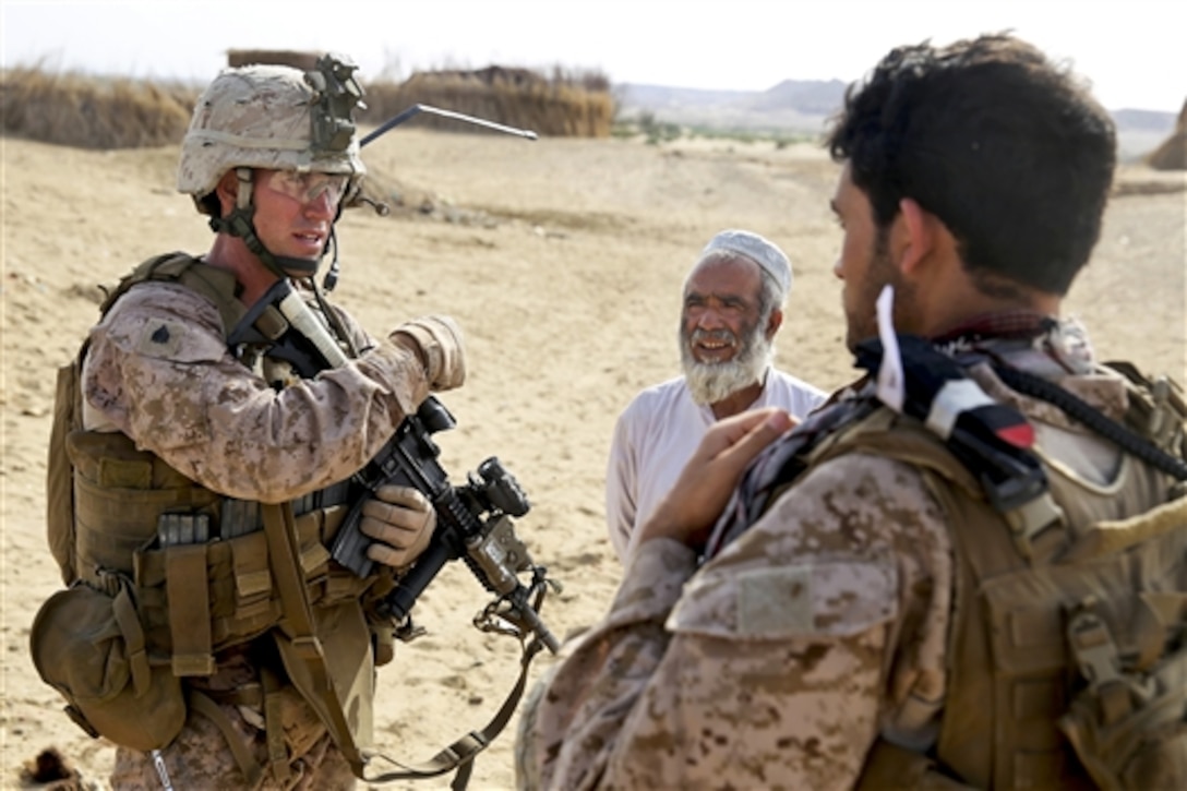 U.S. Marines Corps Sgt. Warren Sparks, left, gets help from an interpreter to gather intelligence from an Afghan elder during a mission in Tagvreshk village in Afghanistan's Helmand province, May 1, 2014. Sparks, a squad leader, is assigned to Bravo Company, 1st Battalion, 7th Marine Regiment. The Marines conducted the mission to disrupt suspected Taliban forces in the area. 